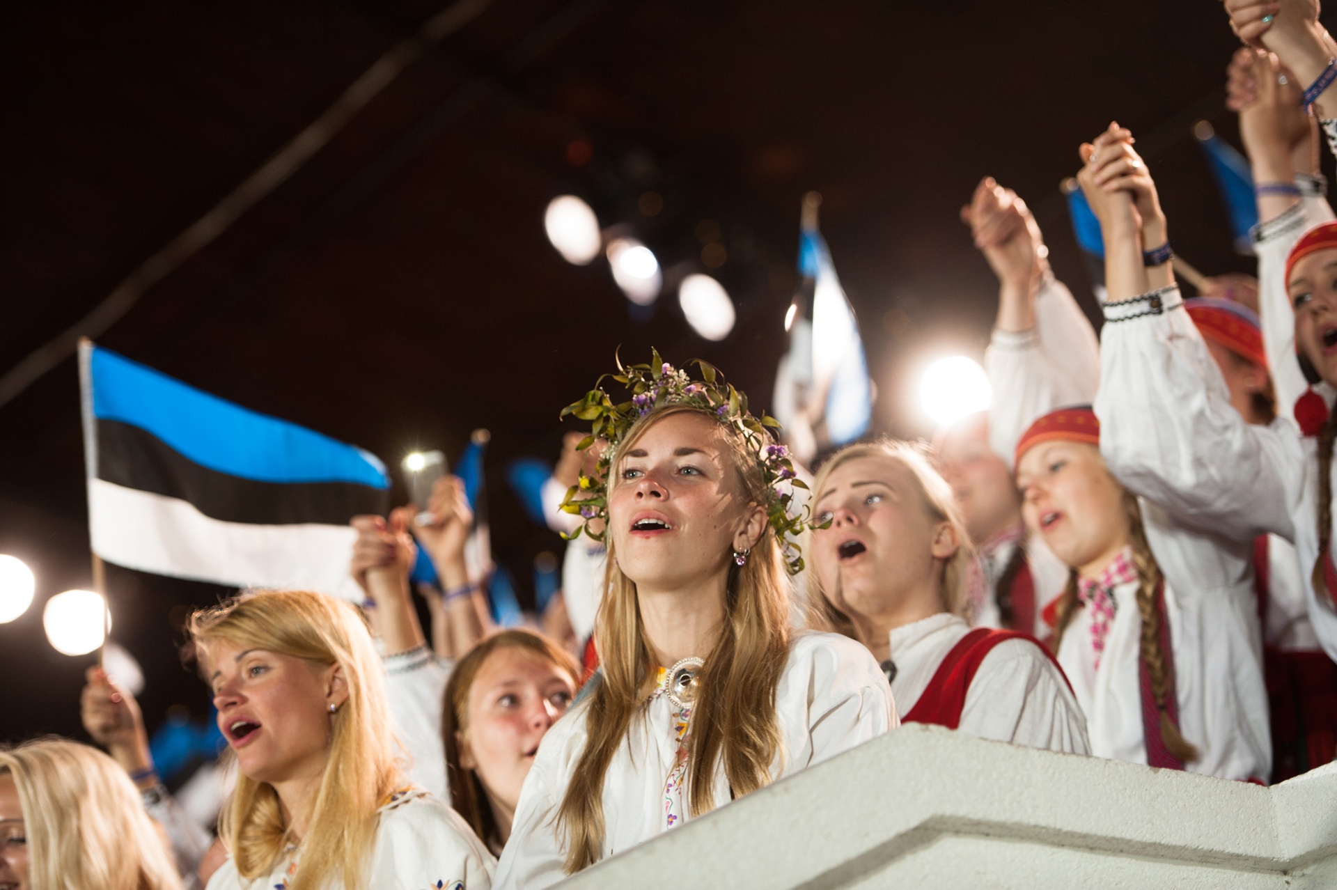 Girls singing during the Song Festival with Estonian flag
