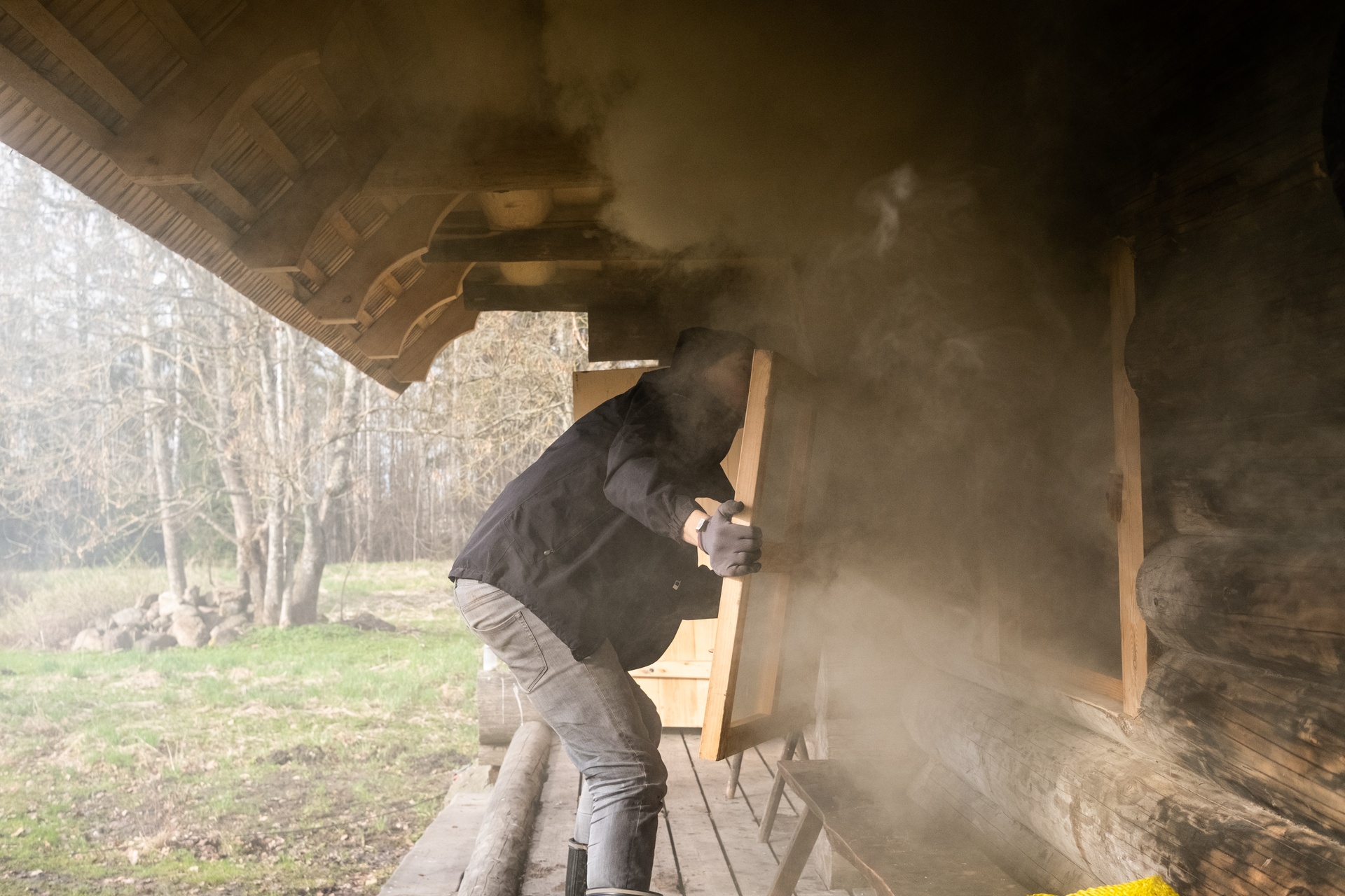 Man opens smoke sauna windows to ventilate sauna before use