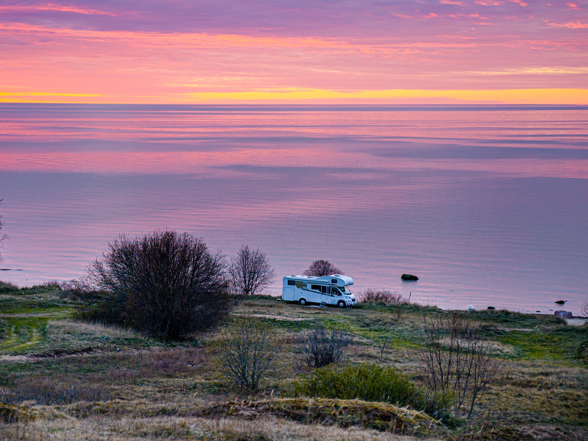 Caravan parked next to the Baltic Sea at sunset
