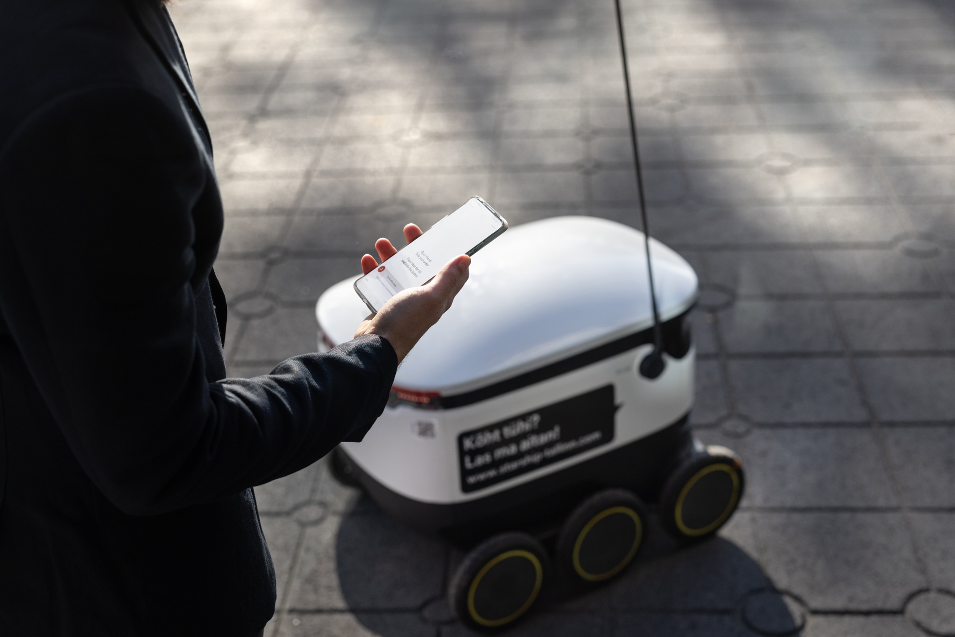 Man using phone for Starship delivery robot