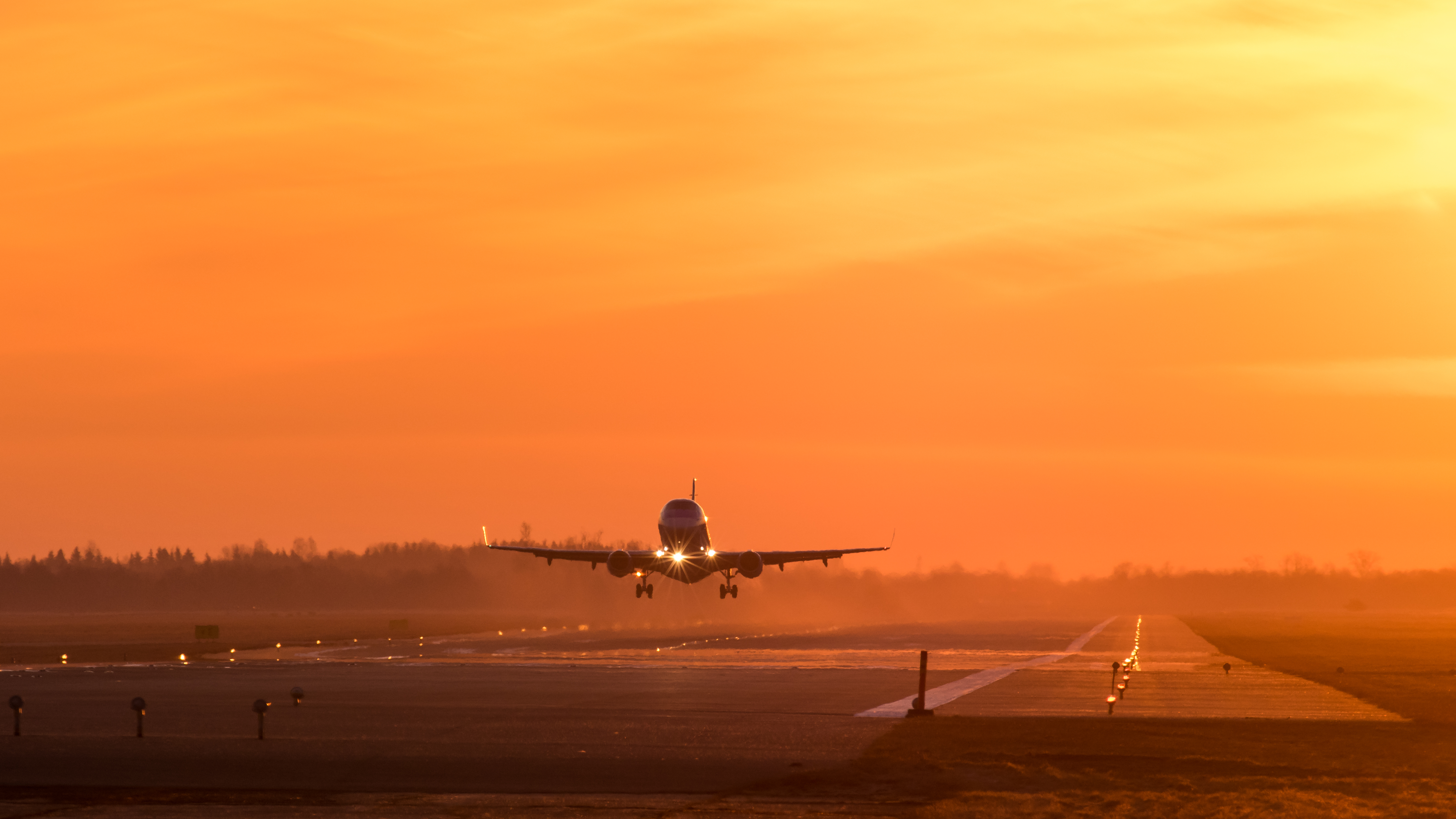 Plane landing in estonian airport in the sunset