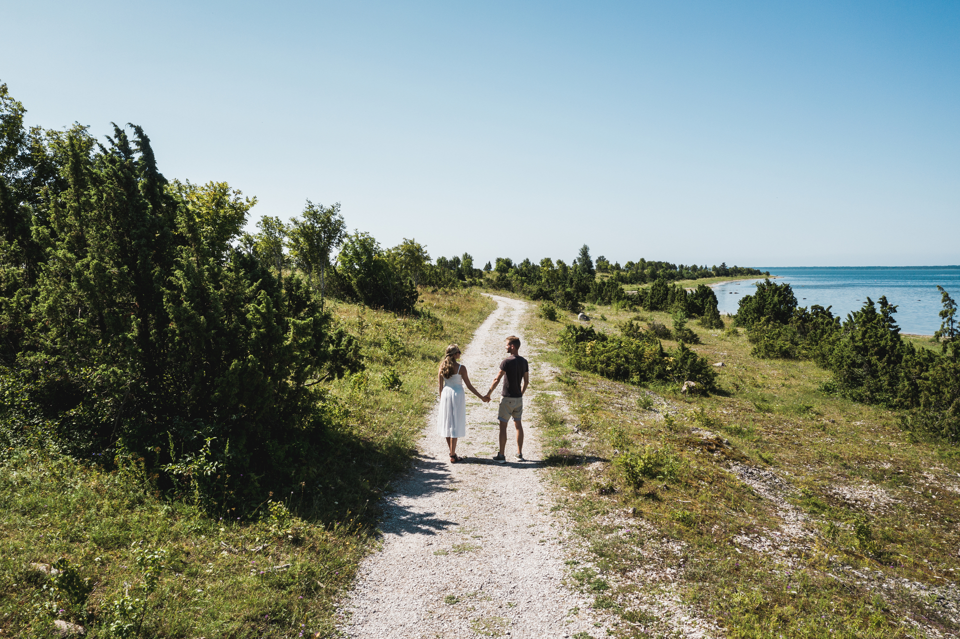 Mies ja nainen kävelevät Sääre tirpin rannalla Hiidenmaalla.