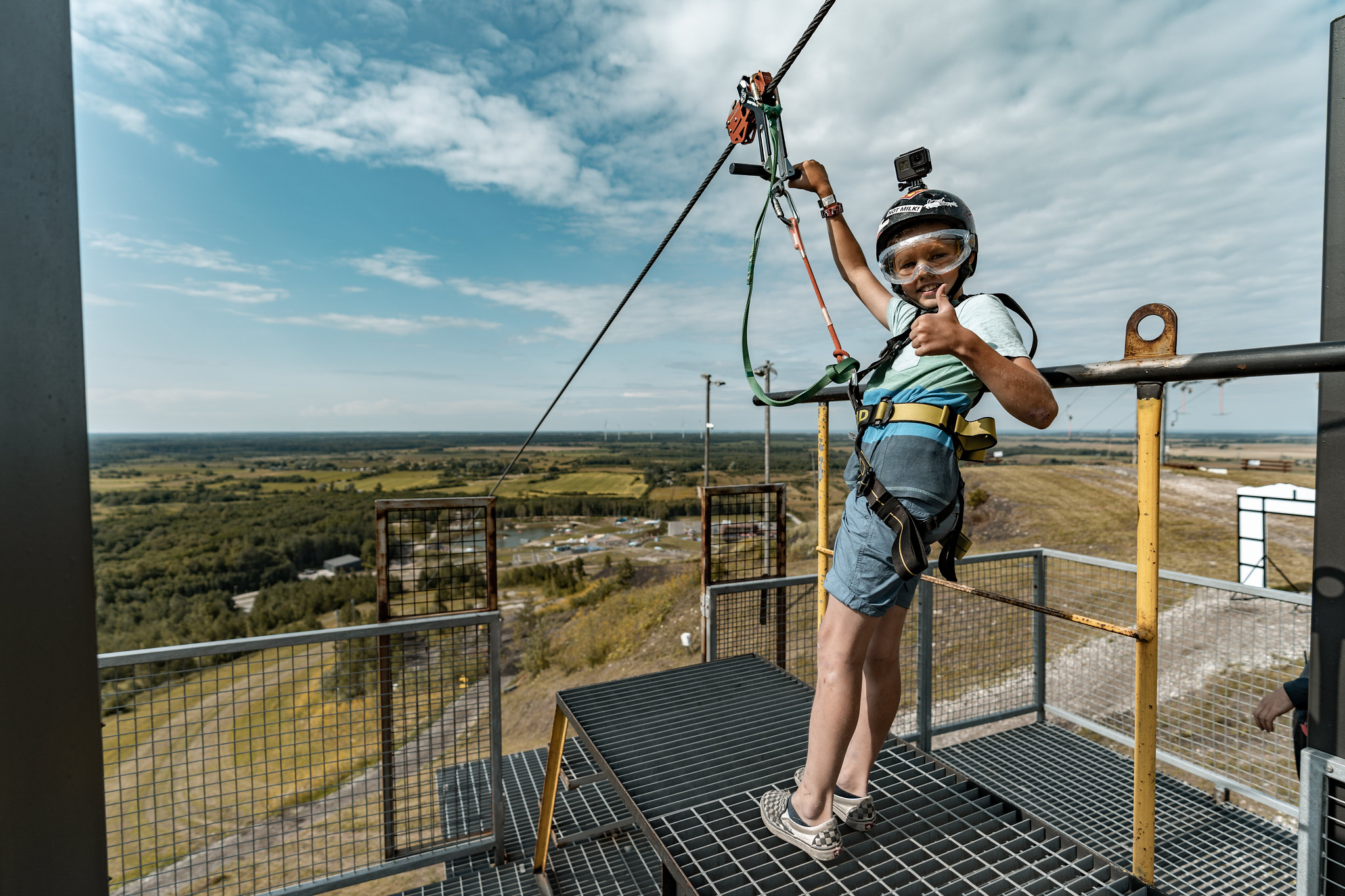 Child gives thumbs up before going on zipline