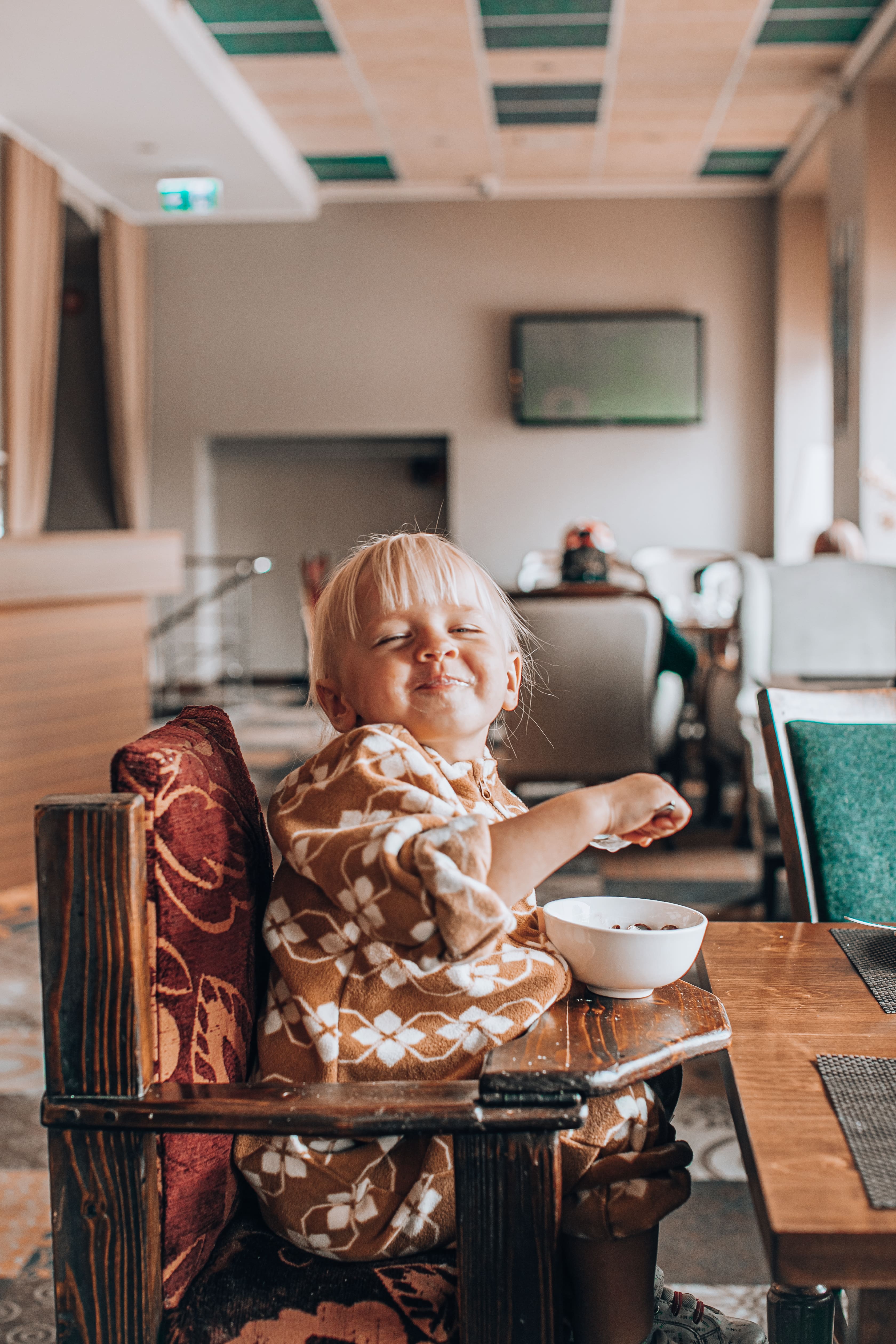 Little girl eats happily at a restaurant in Narva