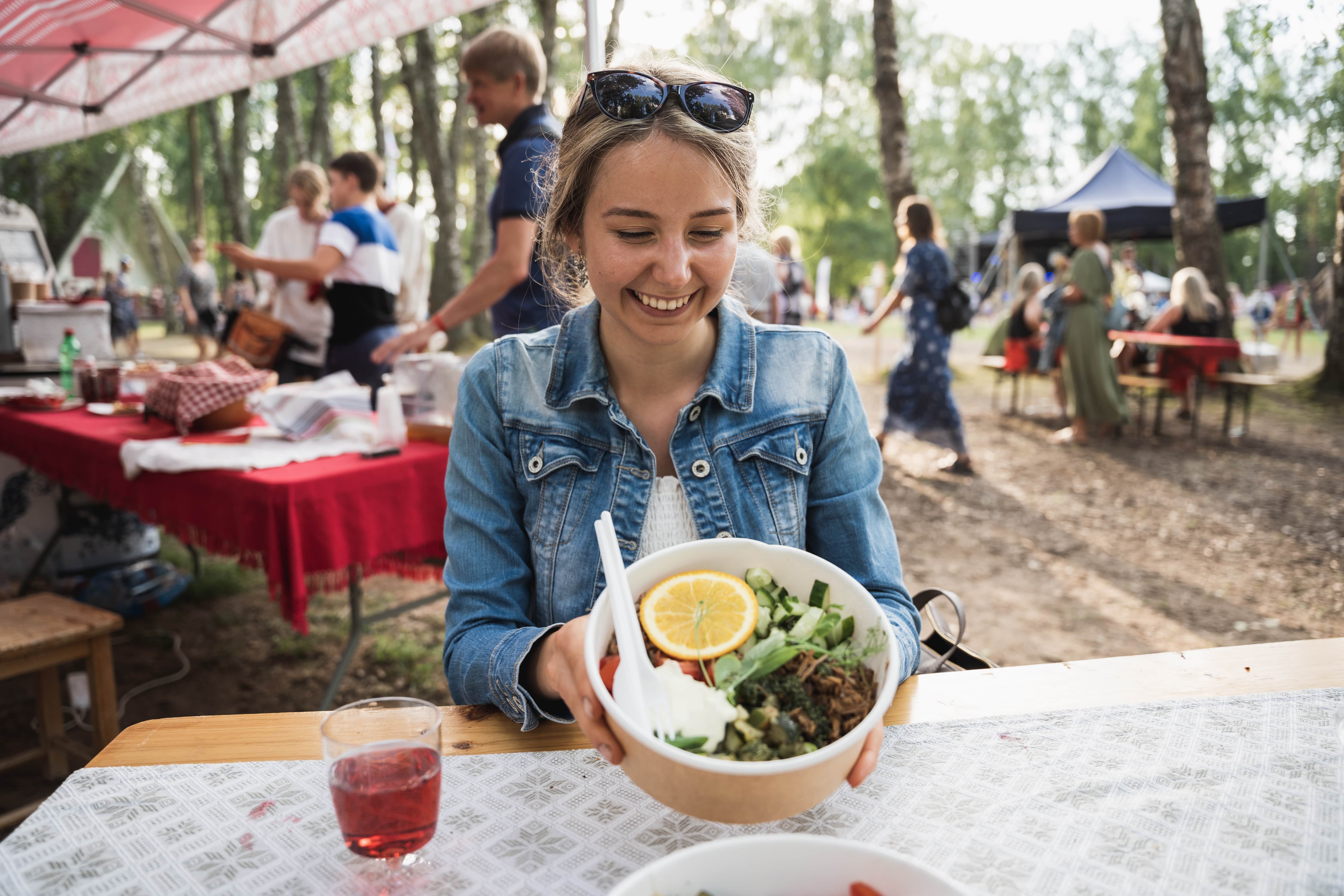 Woman displays bowl of food at Seto Folk festival