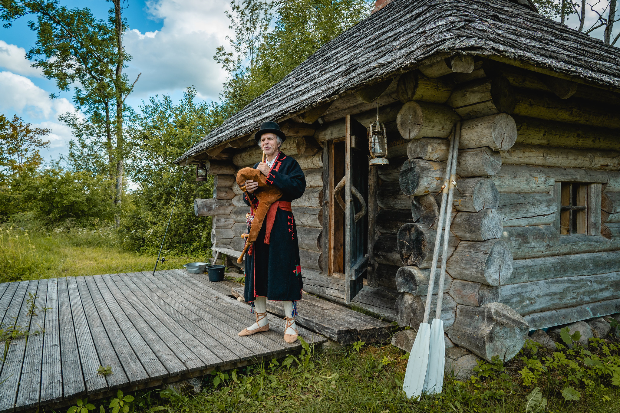 Mulk man standing on terrace of traditional wooden house