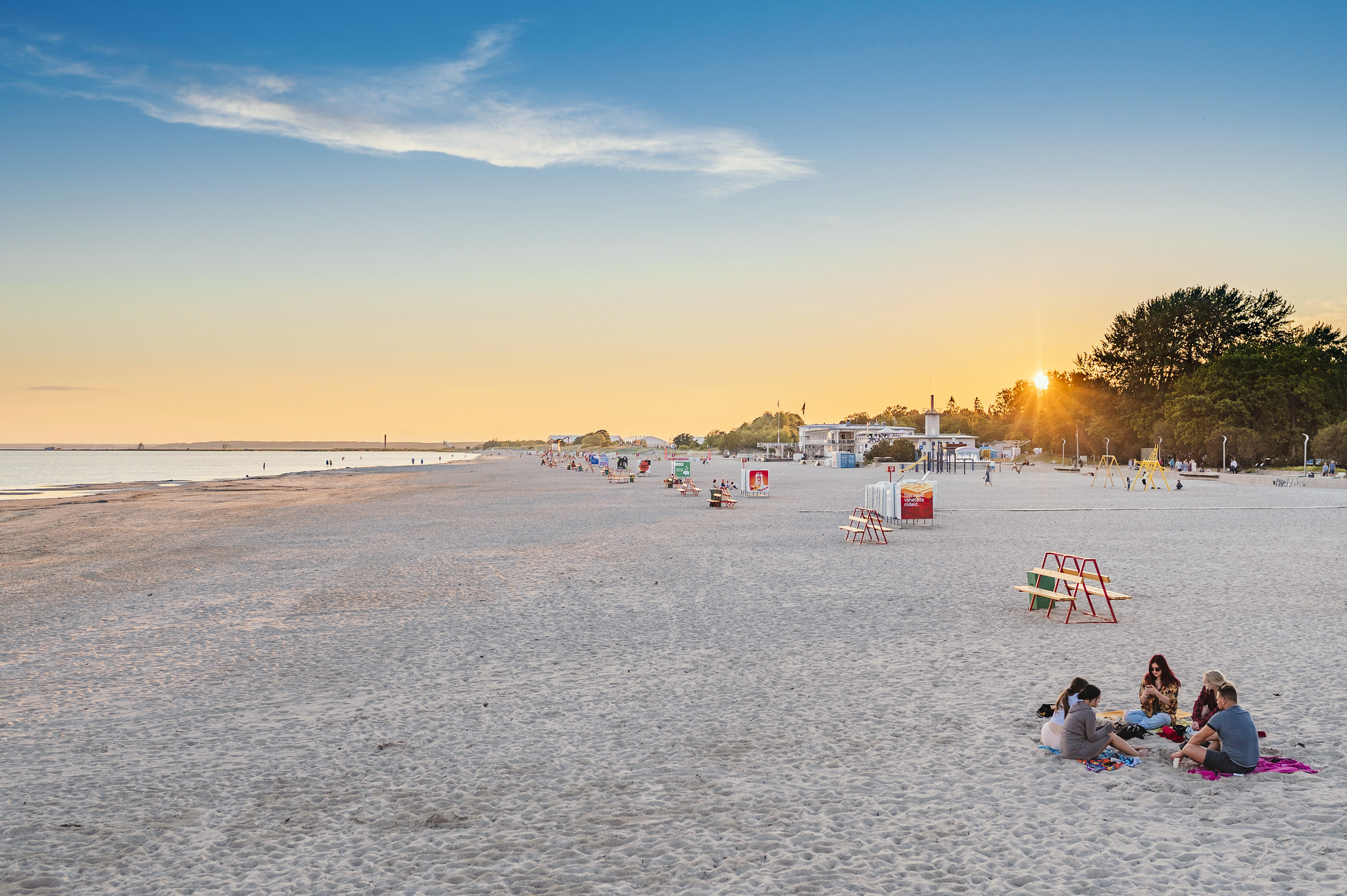 Pärnu beach sunset and people sitting on sand