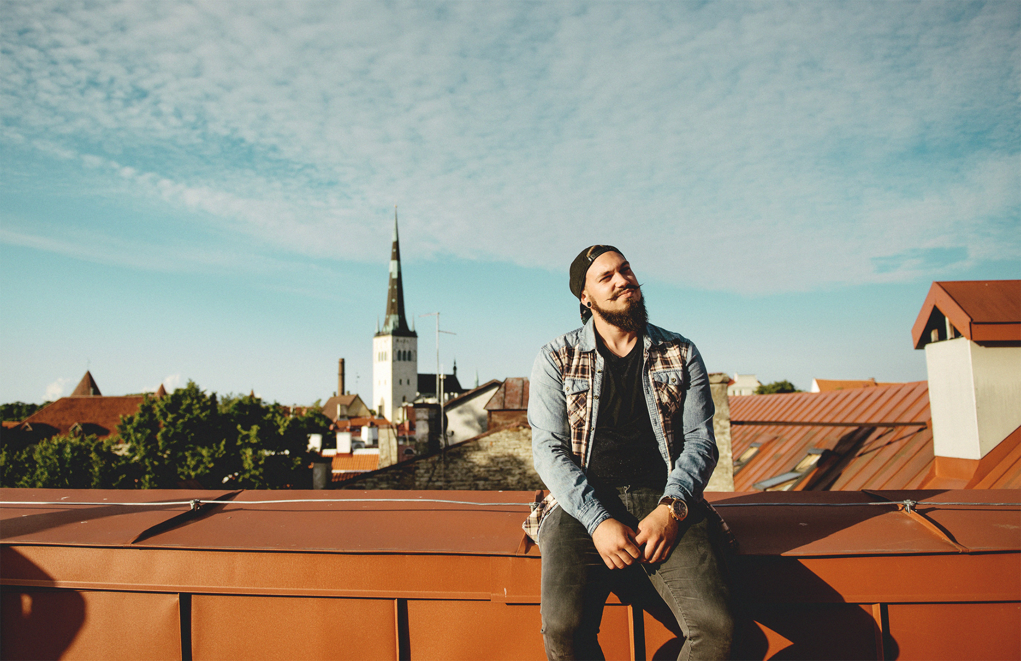 Ein Mann sitzt auf einem Hausdach in Tallinn