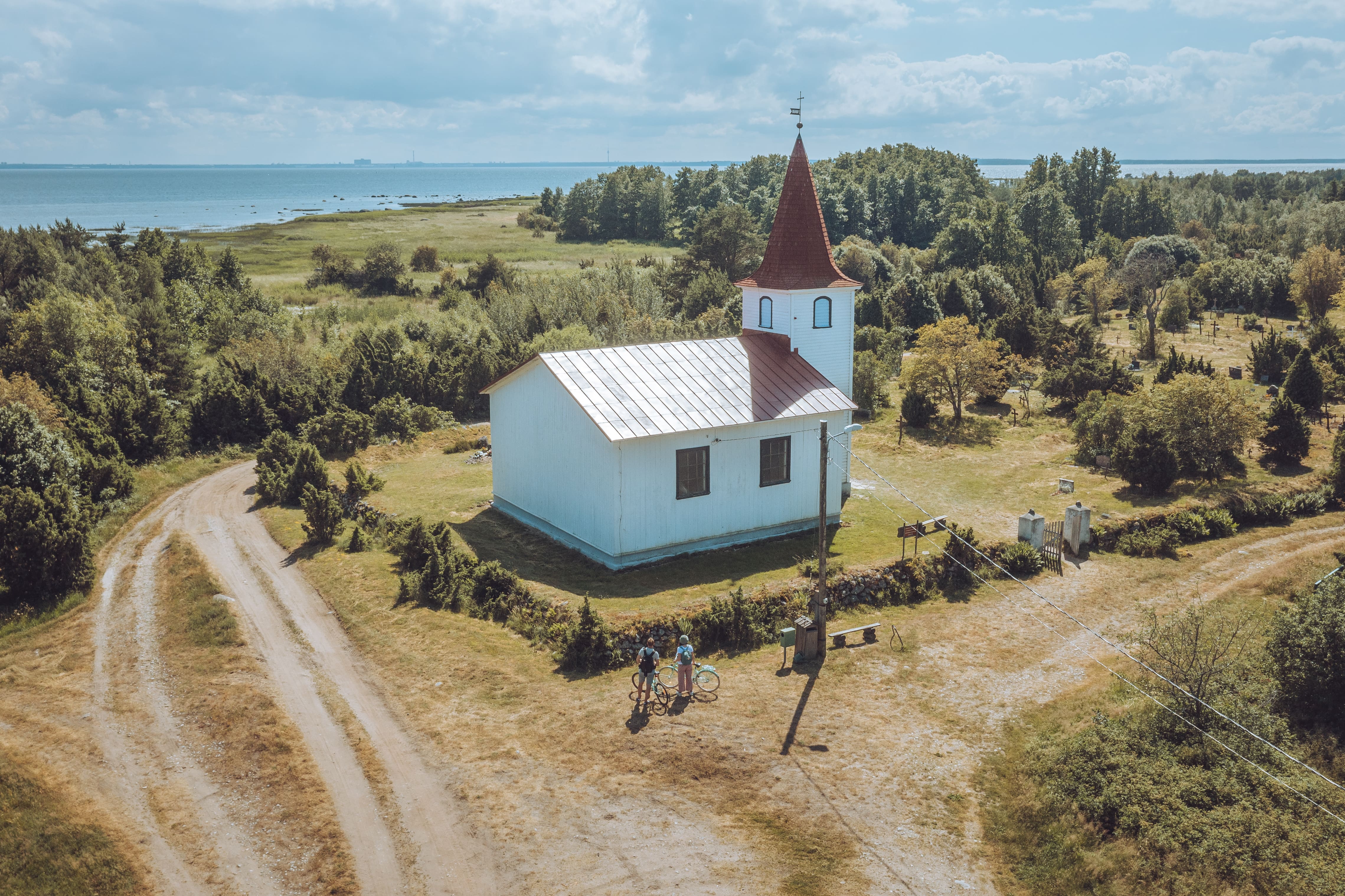 Two people look at Prangli Church in Estonia