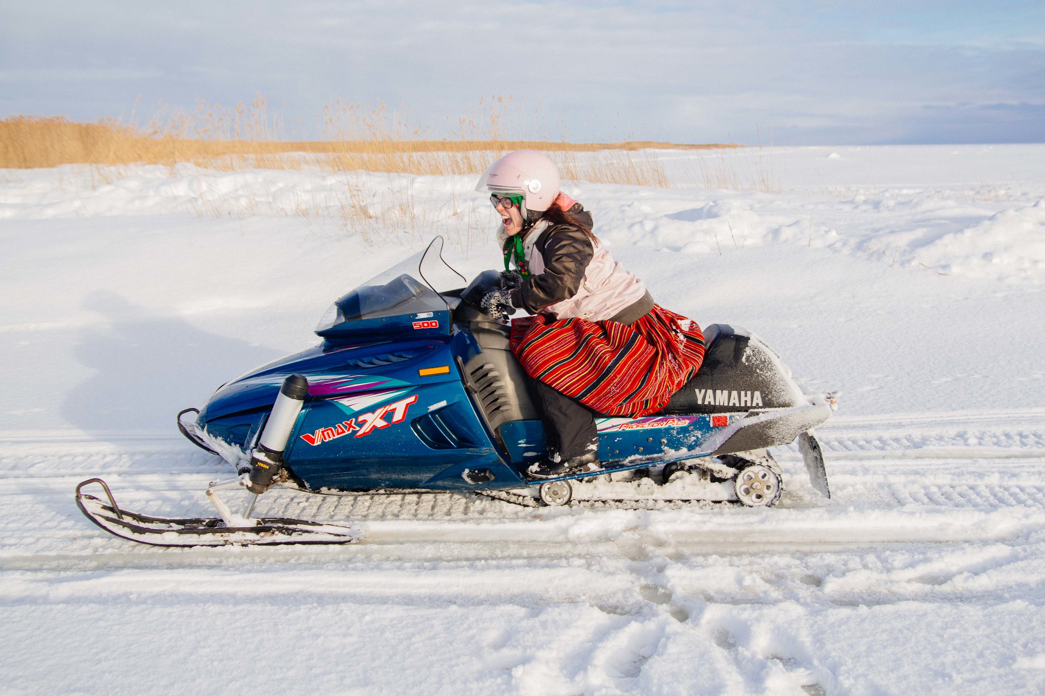 Woman driving snowmobile on Kihnu Island in winter