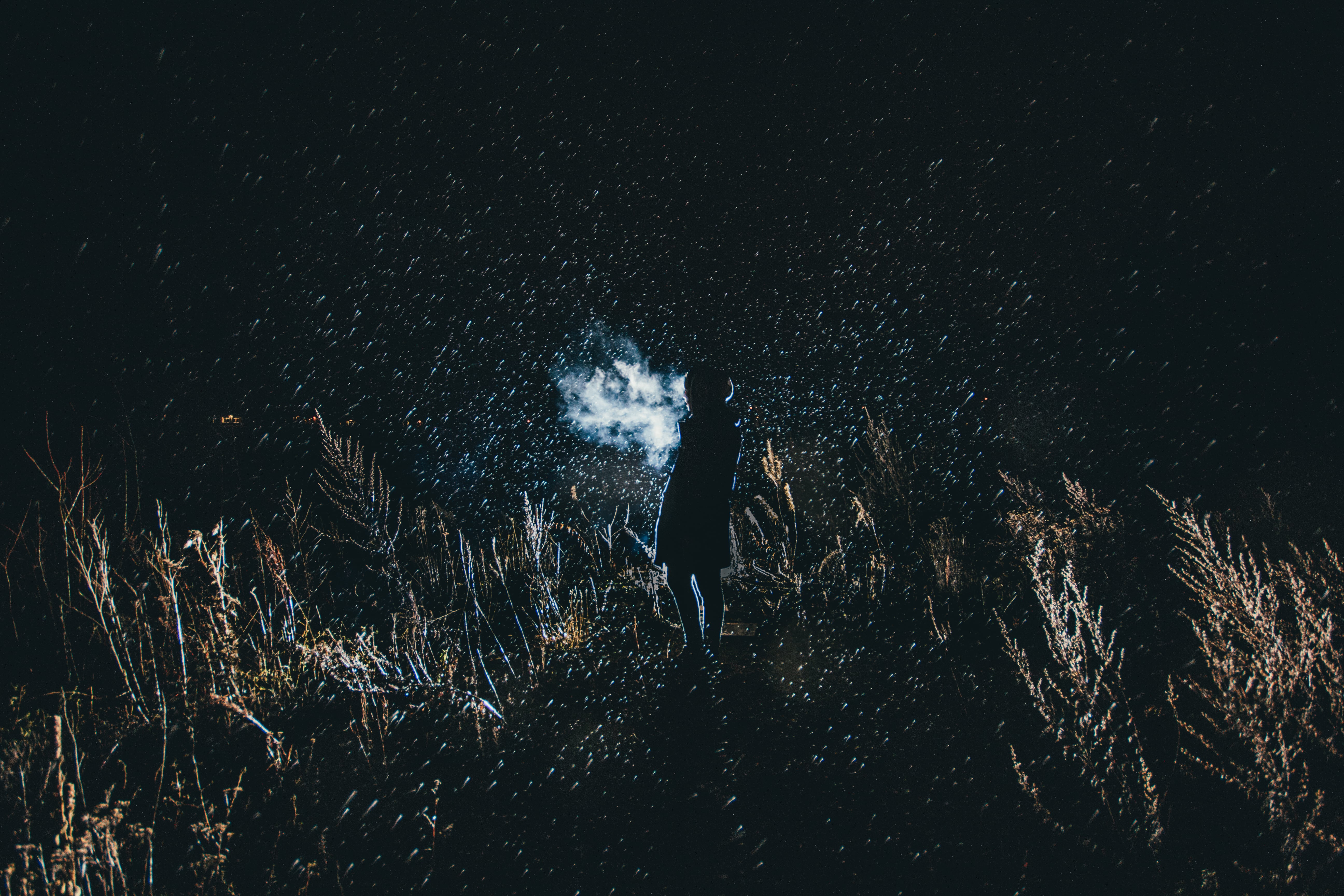 Person stands in dark starry night, can see breath