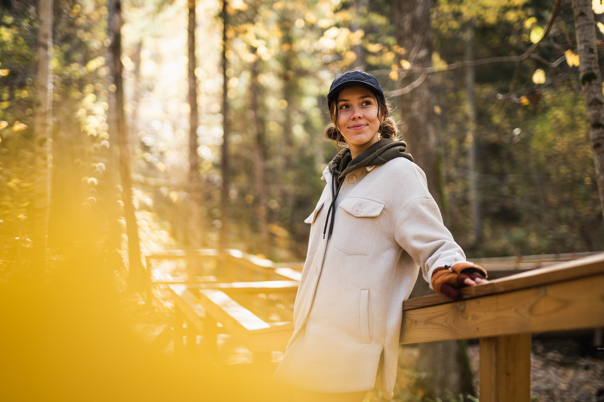 Woman resting on wooden stairs in autumn forest in Pärnumaa