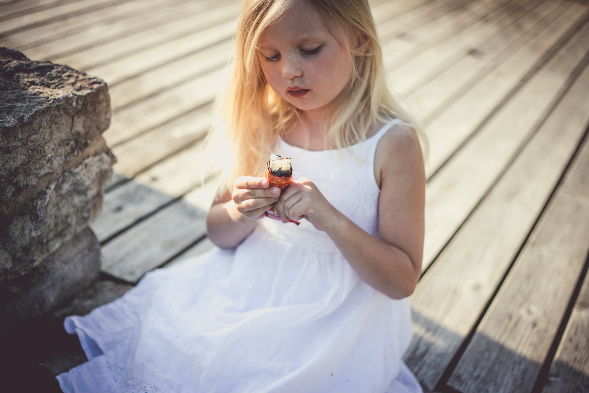 girl in white dress eats kohuke snack in Estonia