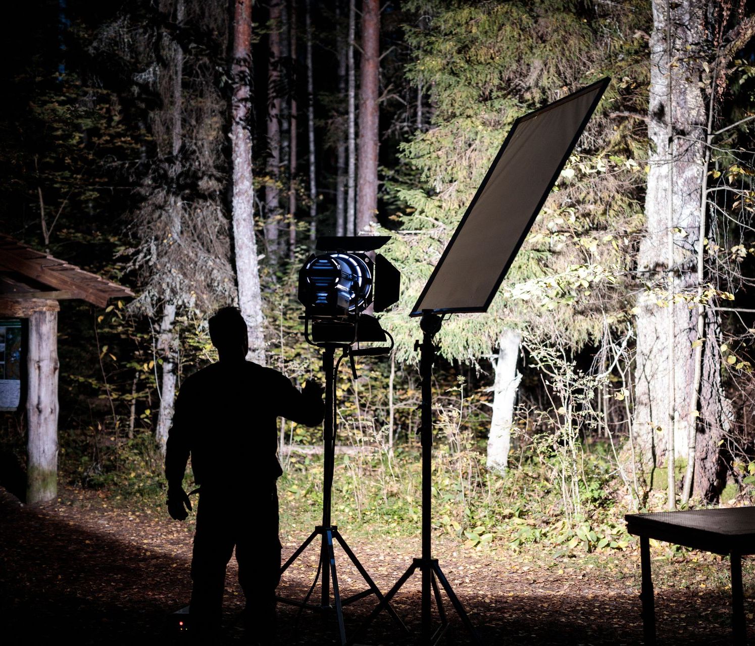 Mies asettelemassa luontovideoinnin valoja ja tarpeistoa