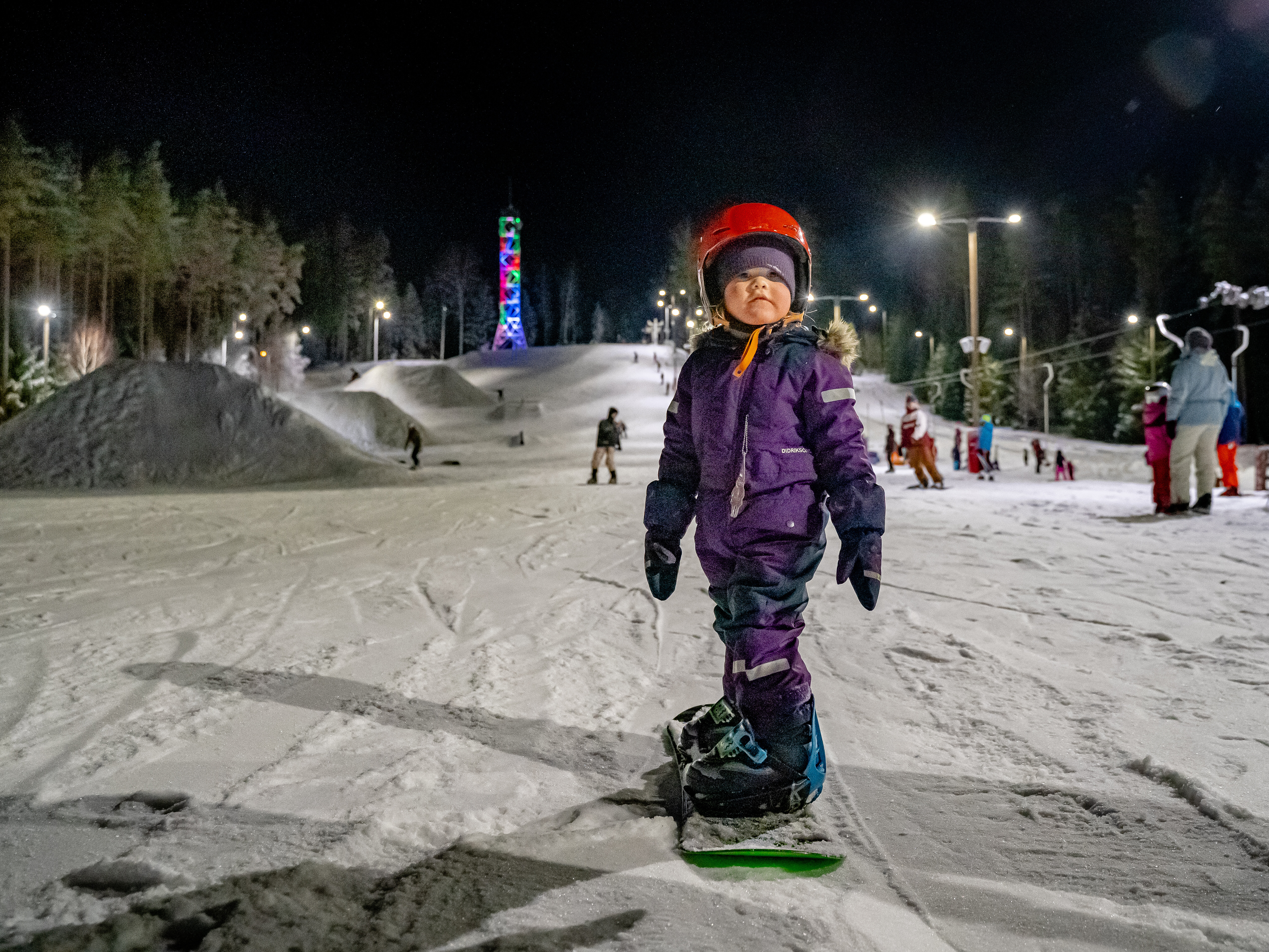 Little girl snowboards at ski hill in Central Estonia