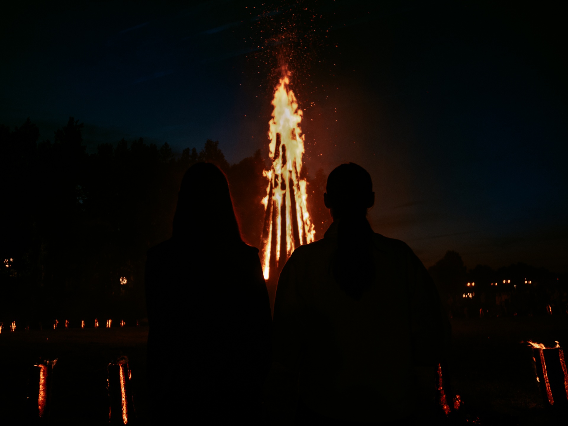 Mies ja nainen juhannuskokkoa katselemassa