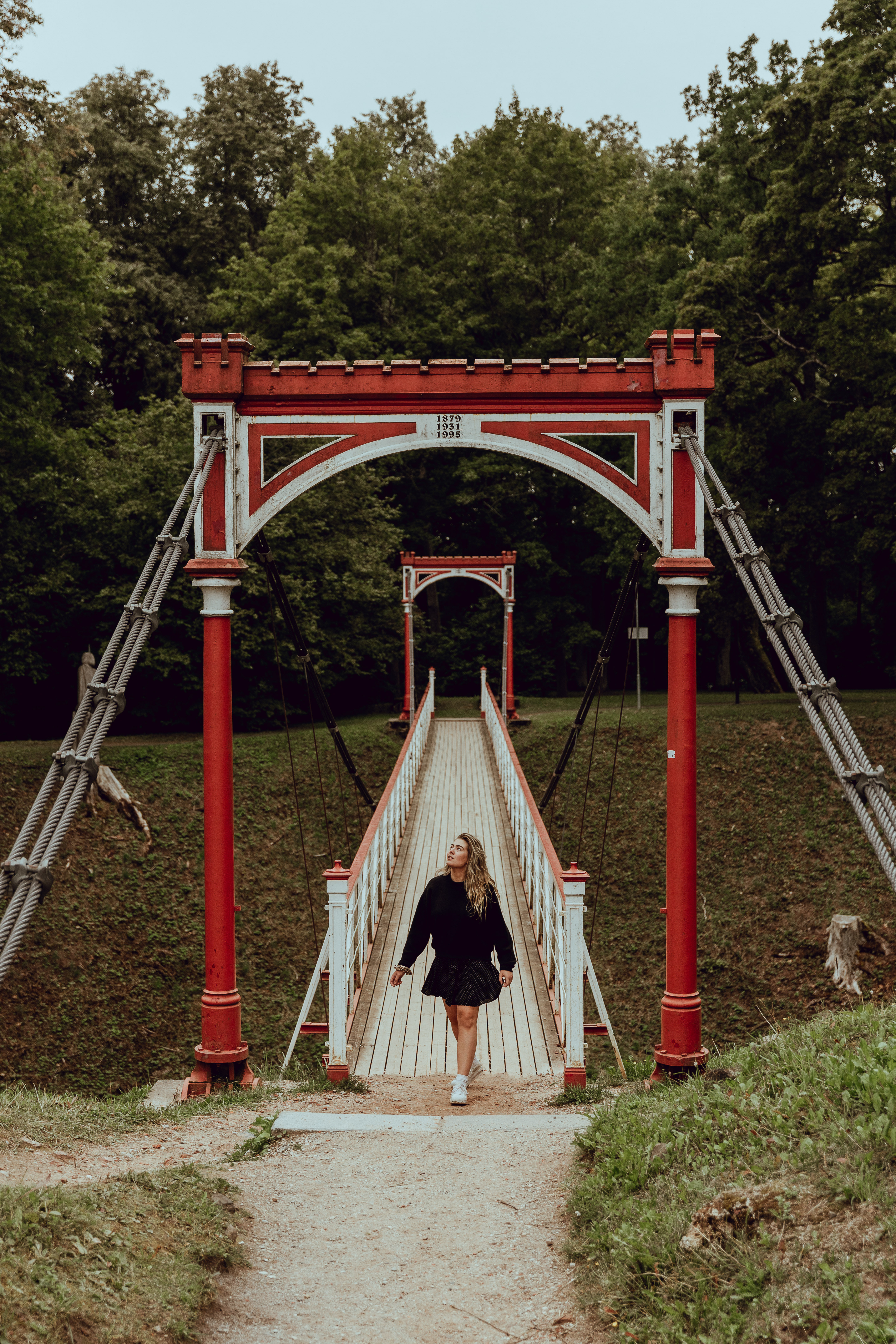 Woman in black dress standing on Viljandi suspension bridge