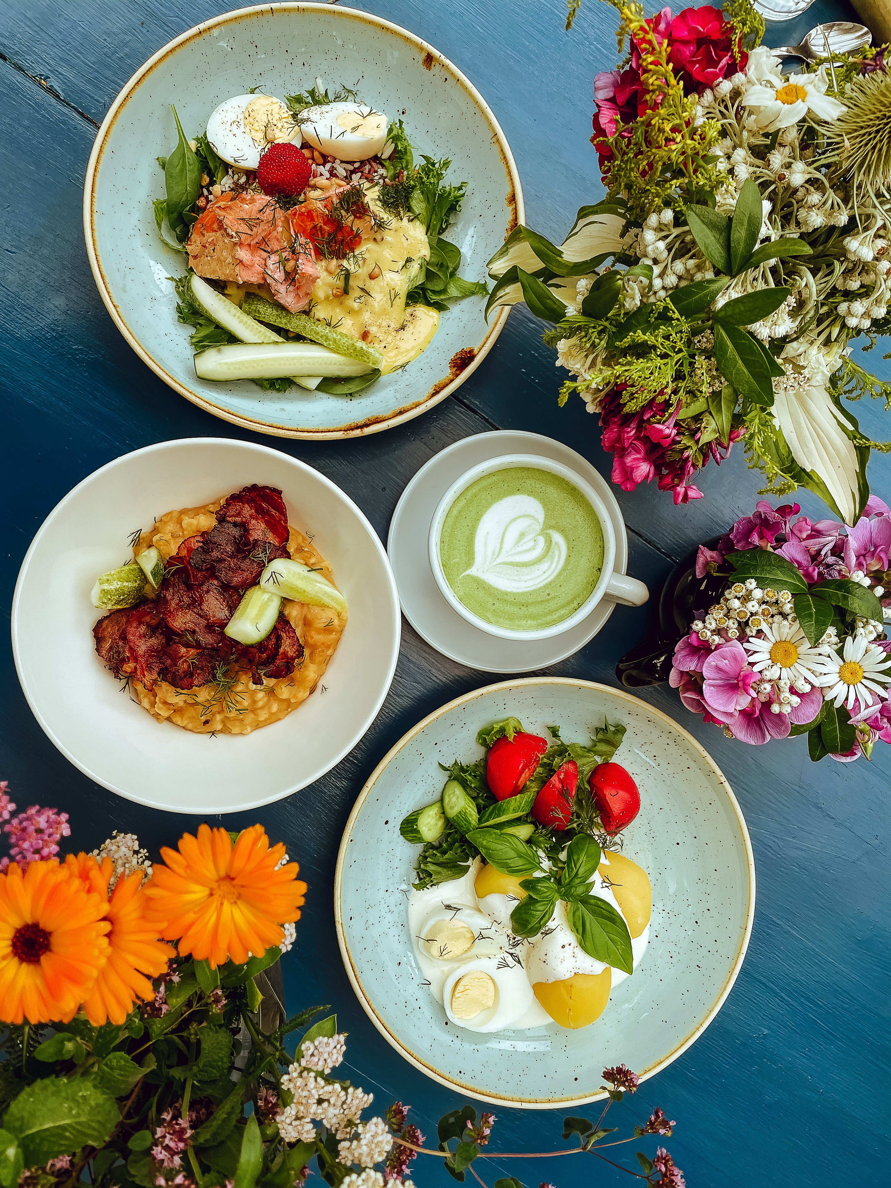 Colorful plates of food and flowers at Roheline Maja