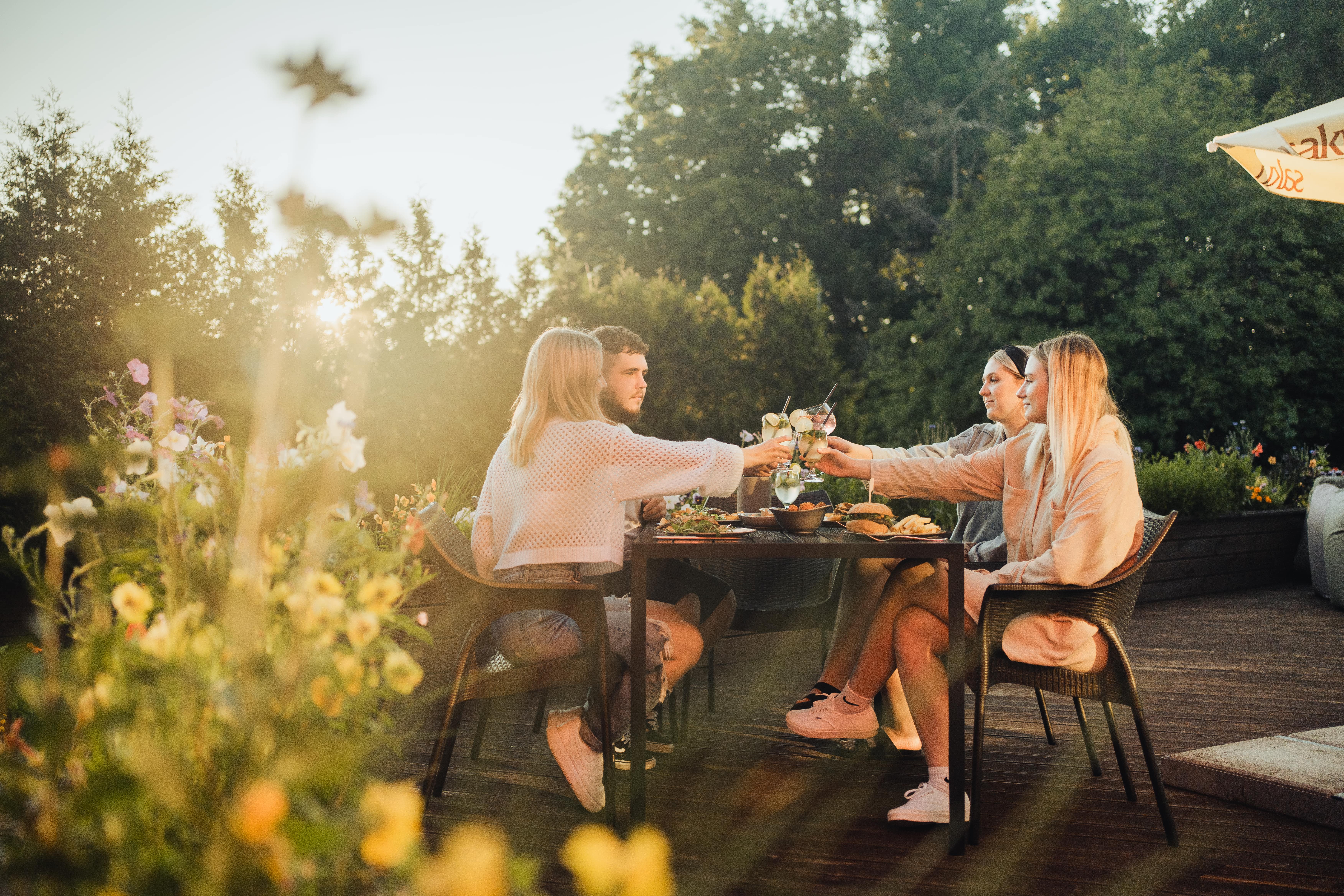 Group of friends eats on a terrace on Muhu Island in summer