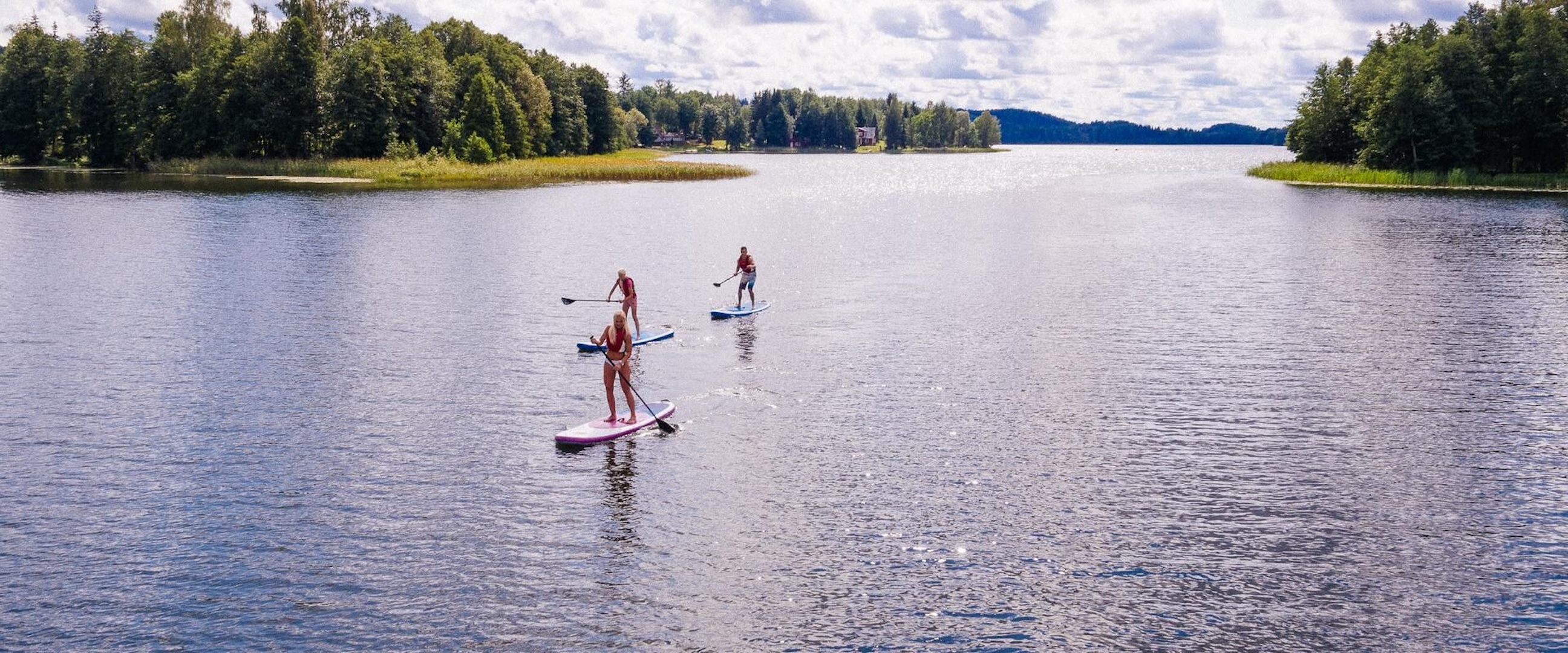 Three people standup paddle on Lake Pühajärv in Otepää