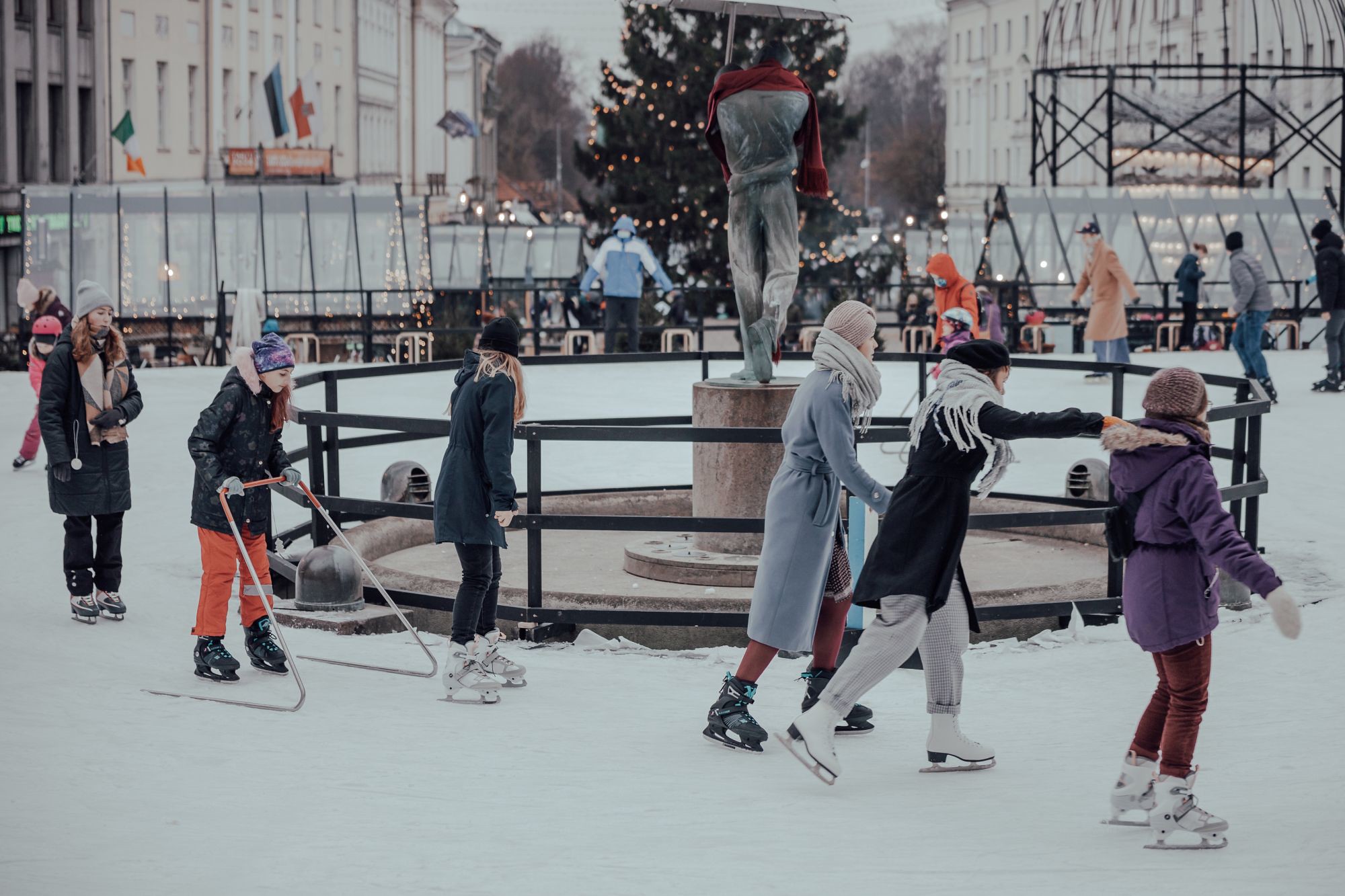 People ice skate in Tartu around Kissing Students statue