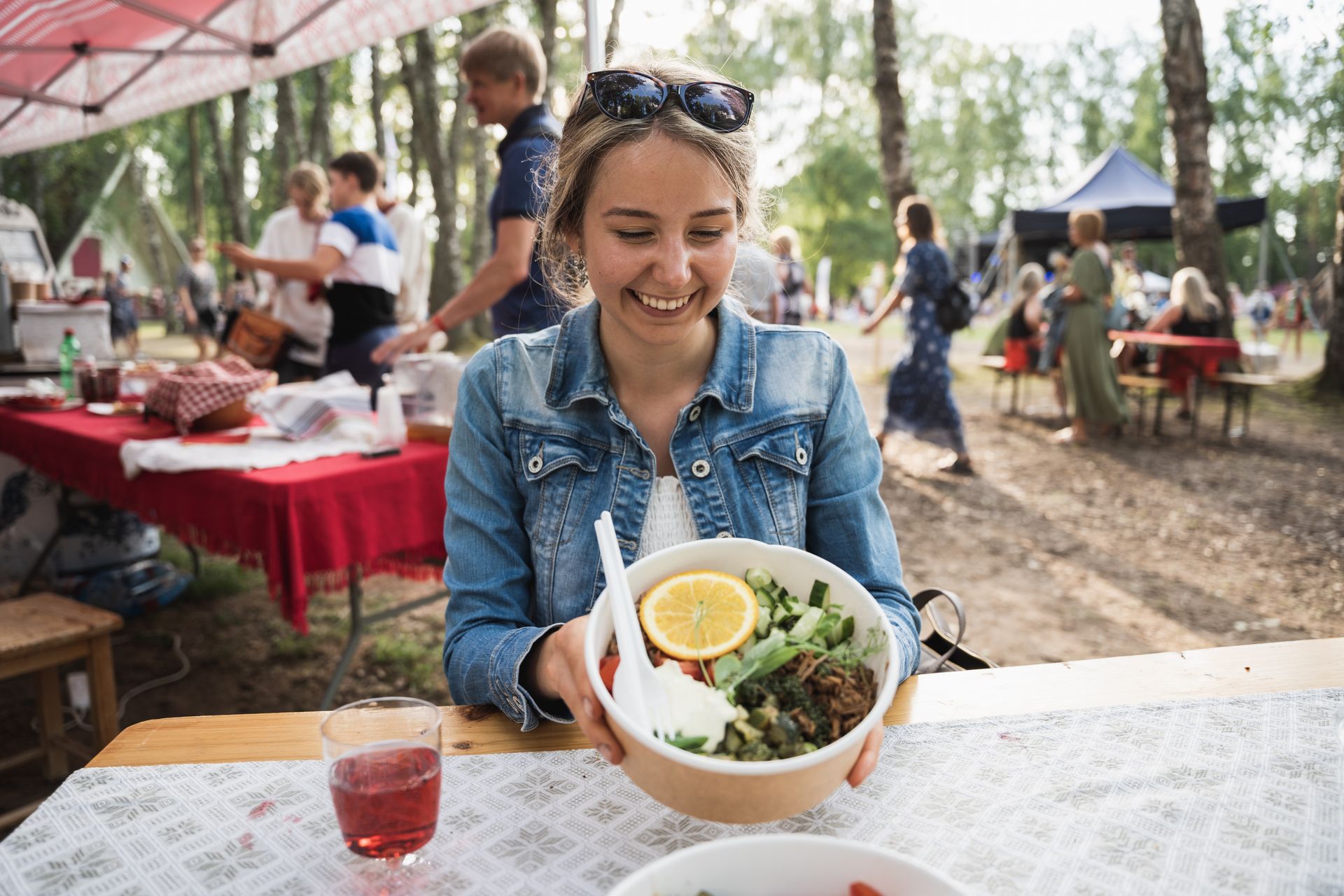 Nainen pokebowl-annoksen kanssa festivaalien ruoka-alueella