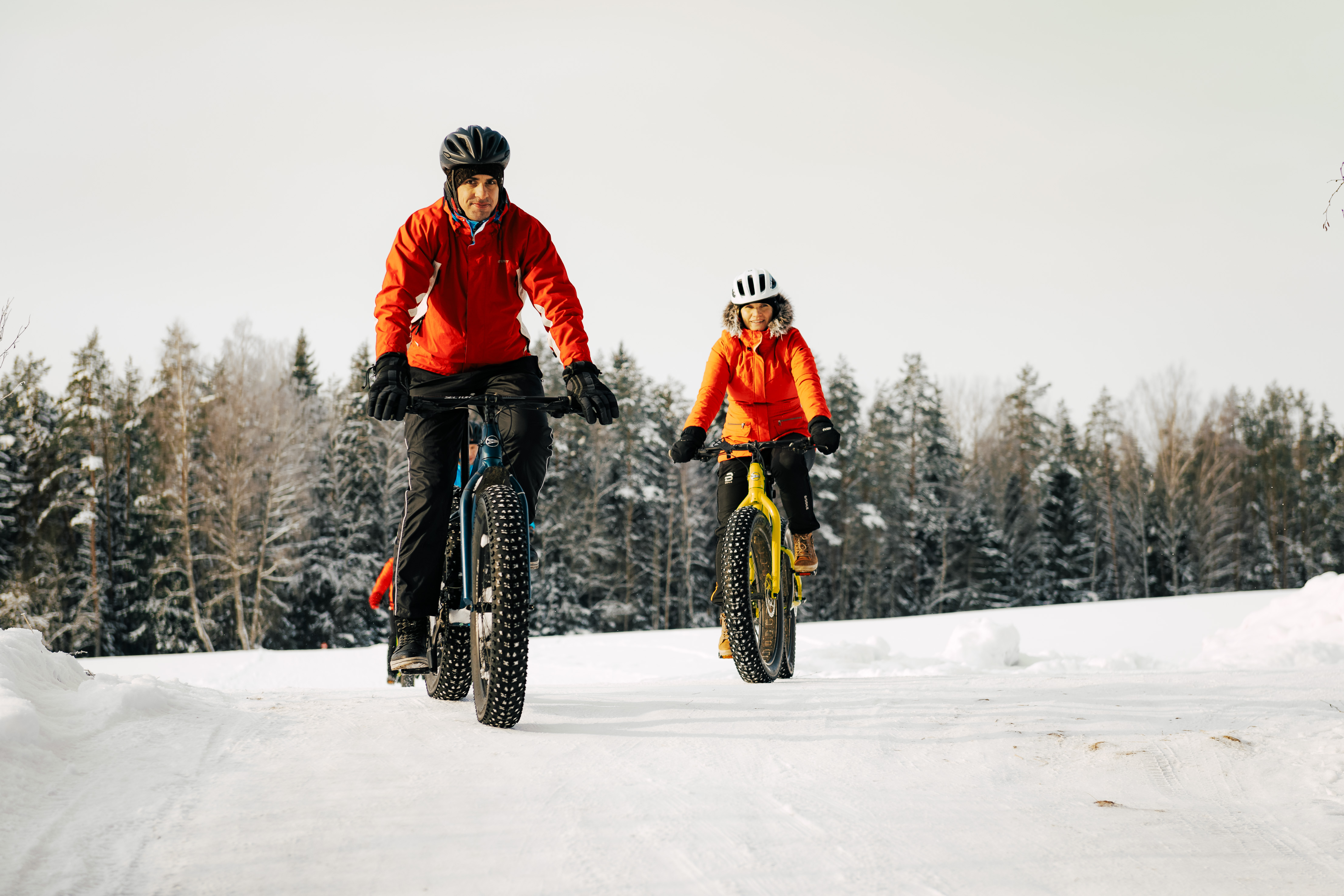 Man and woman riding fat bikes on snow in Estonia