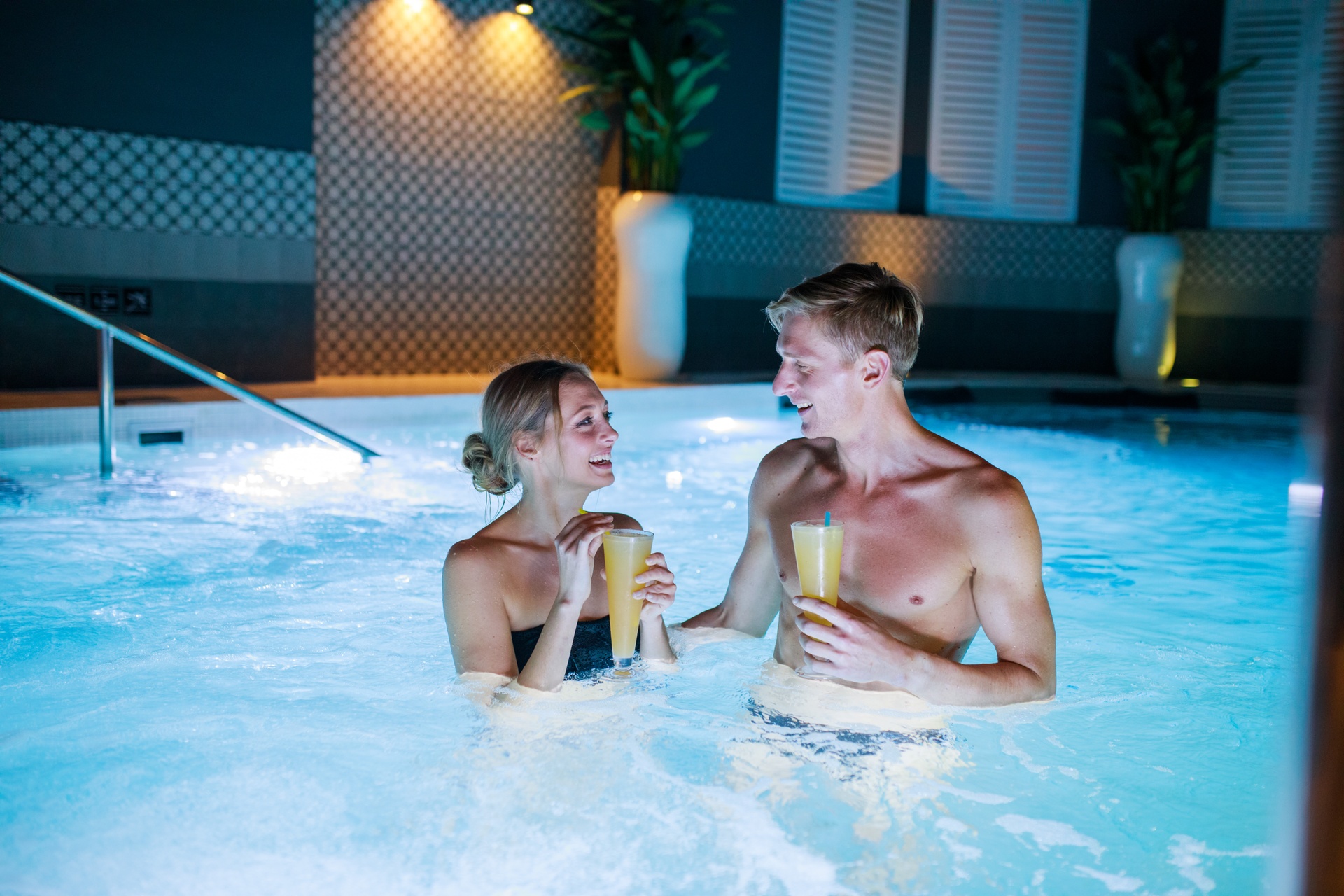 Man and woman with a drink at the pool in a spa in Estonia