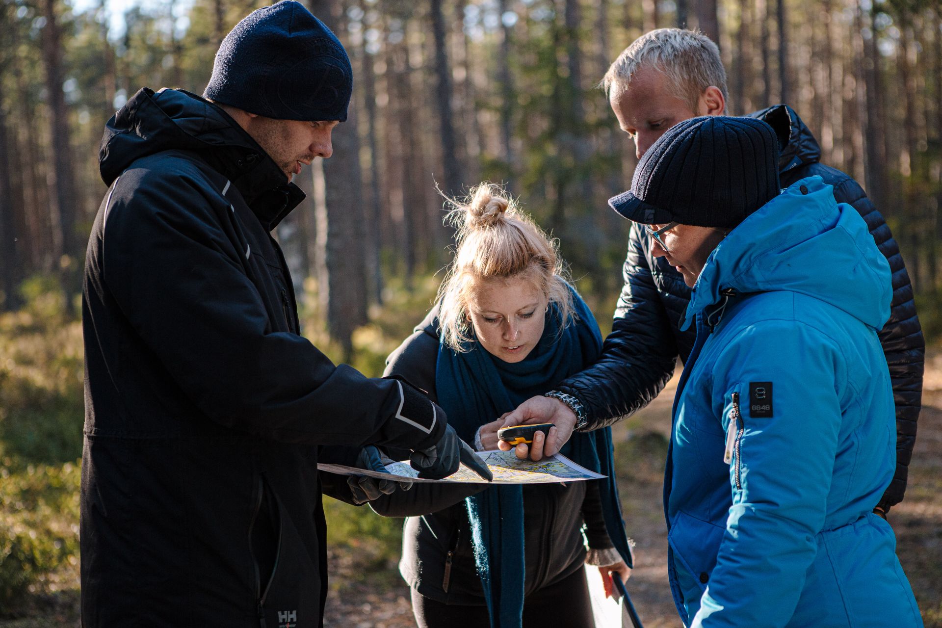 Metsas orienteerujad uurimas kaarti.