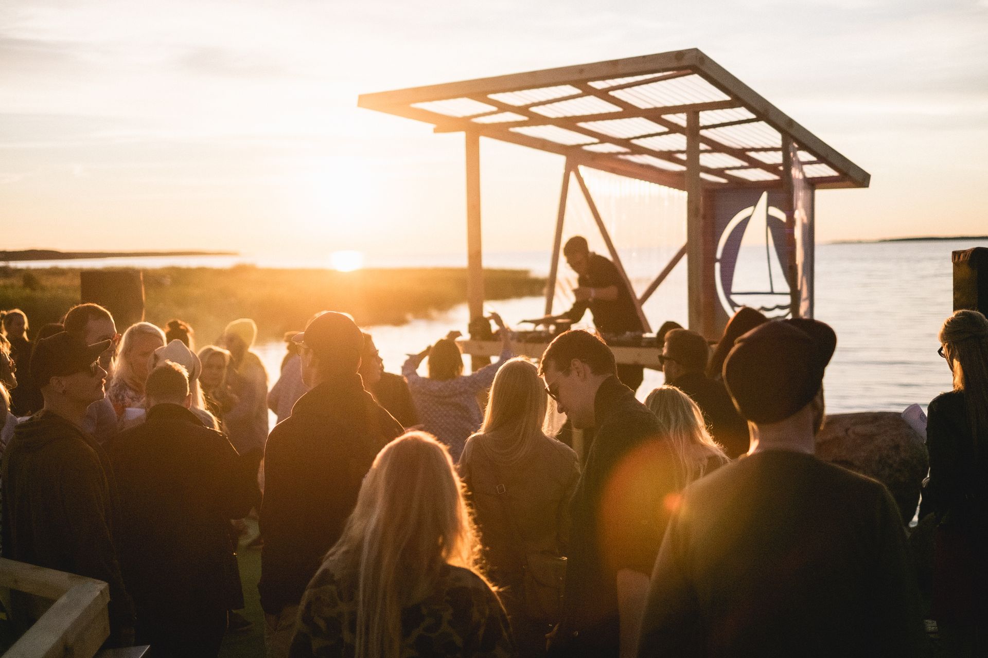 Inimesed tantsivad mere ääres päikeseloojangu taustal