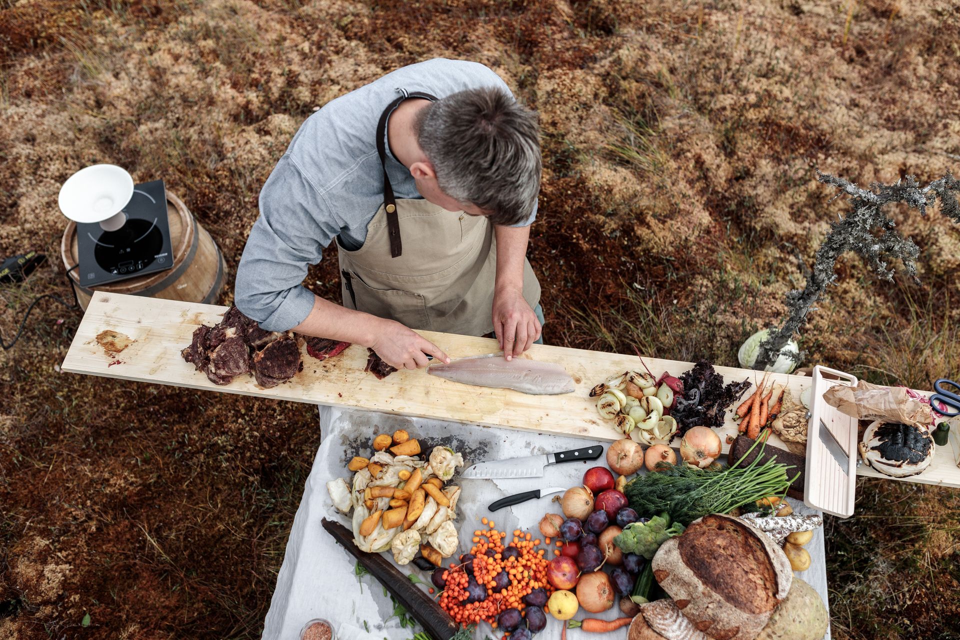 Ein Koch bereitet ein Essen im Hochmoor zu