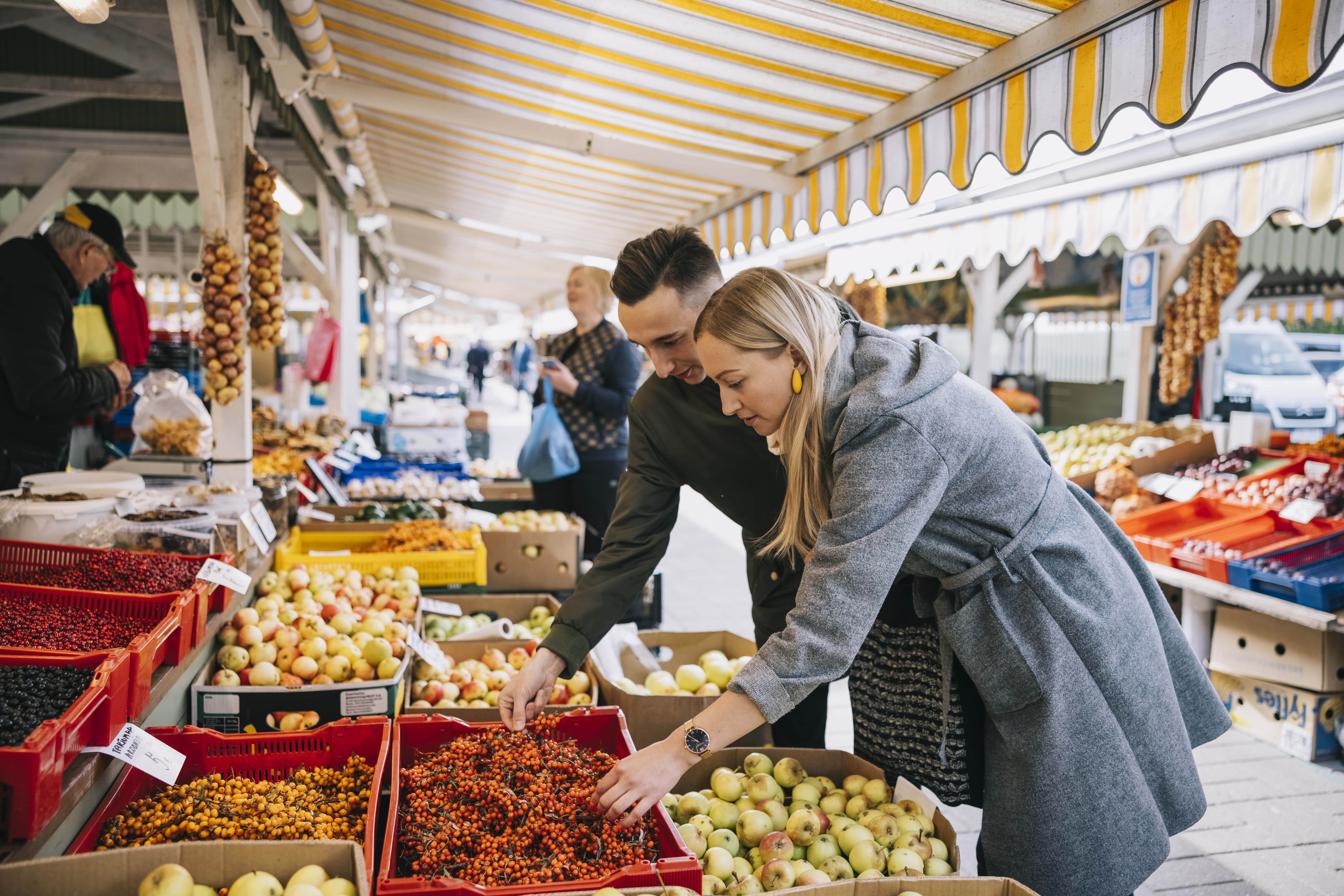 Couple buys seasonal Estonian produce at market in Tallinn