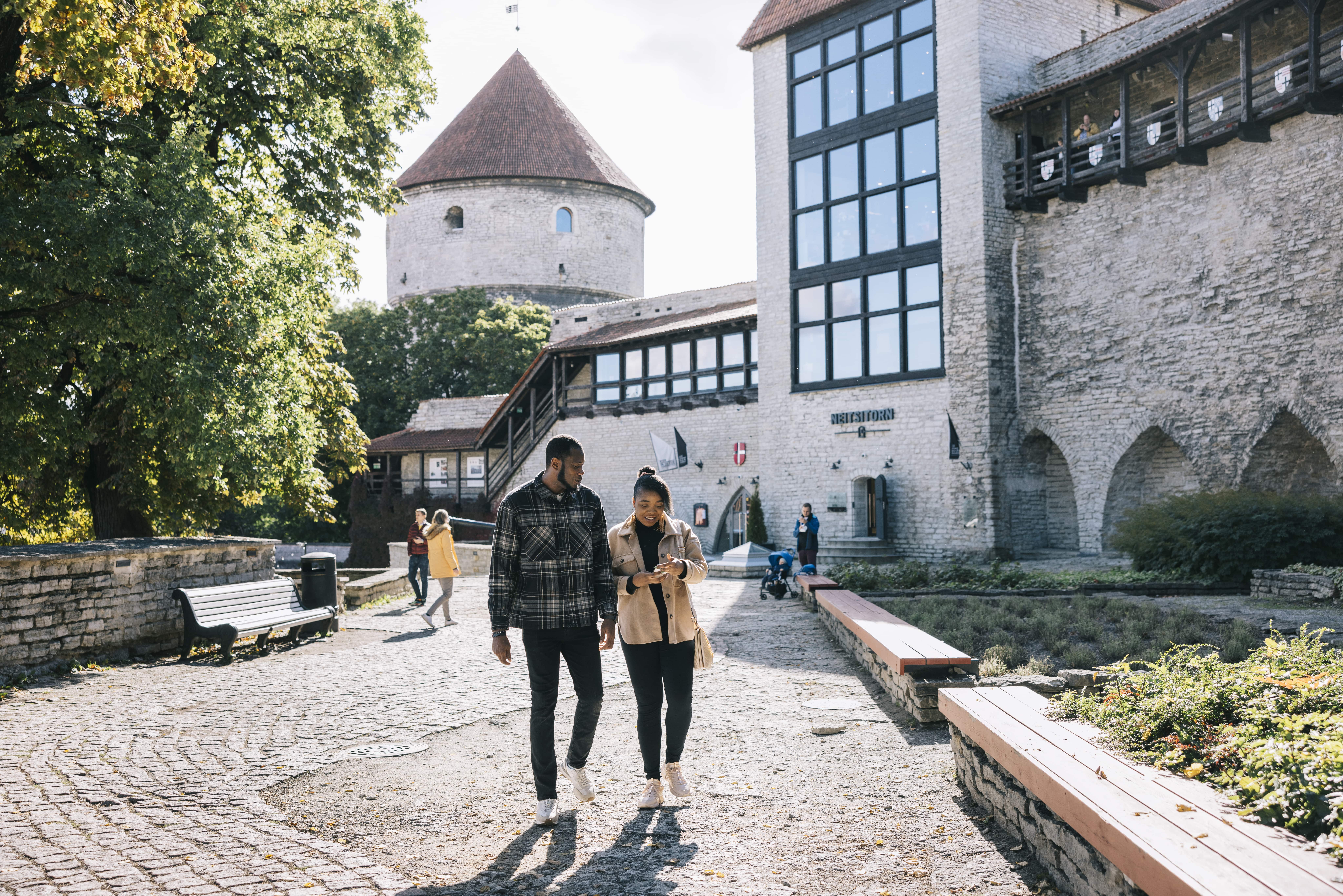 Couple walks in Tallinn's medieval Old Town in summer
