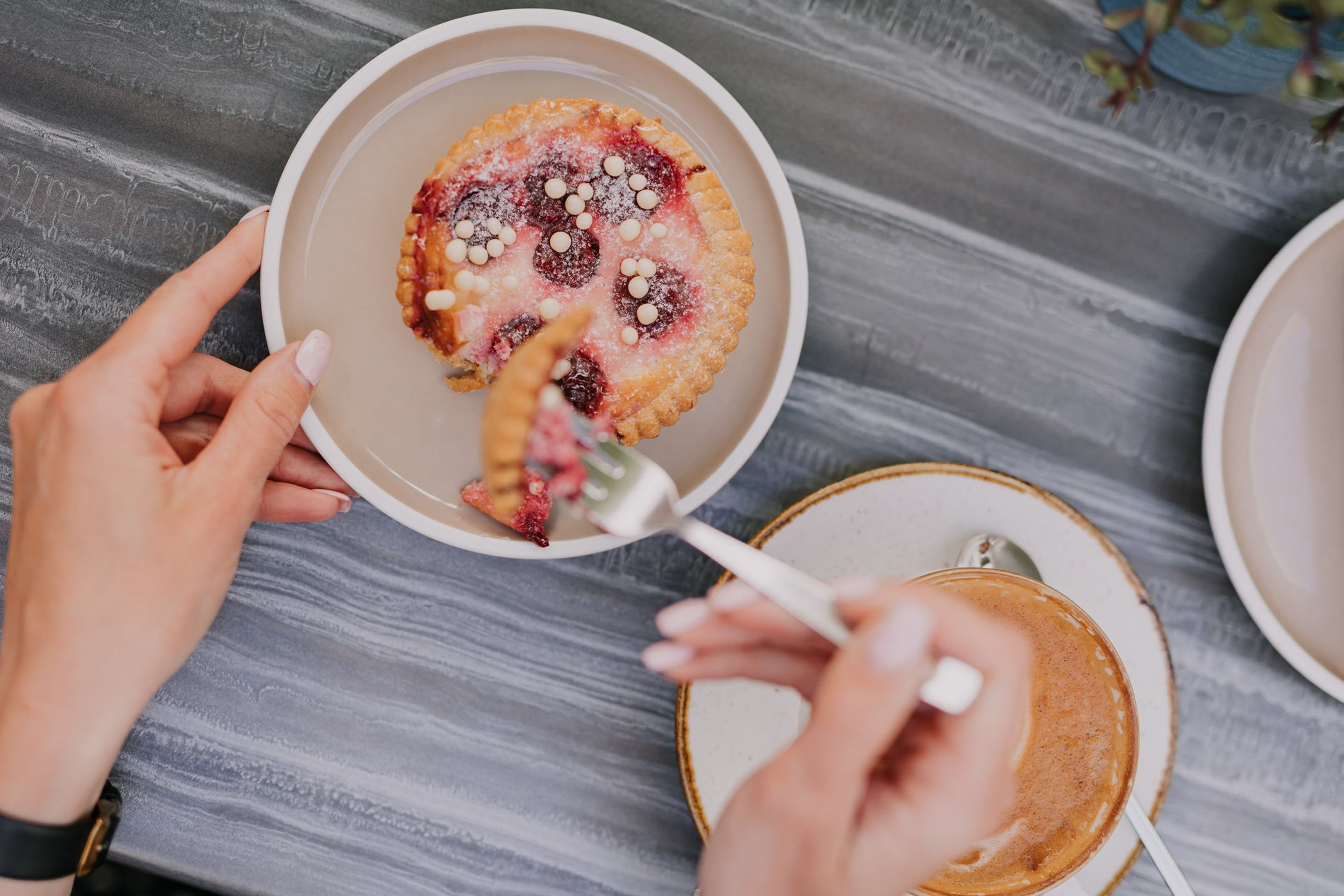 Woman eats pastry at café in Tartu