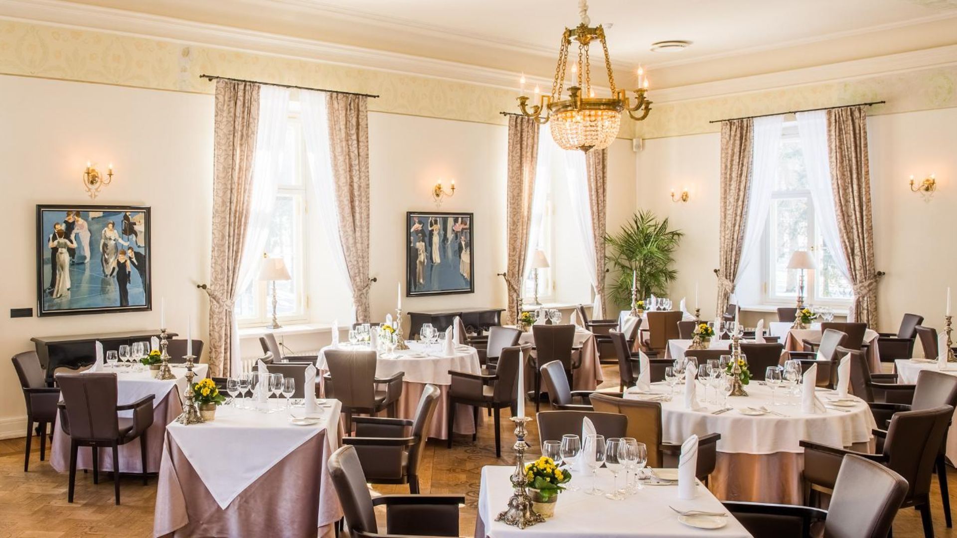 Elegantne restoran klaveri, lühtri ja kaetud laudadega