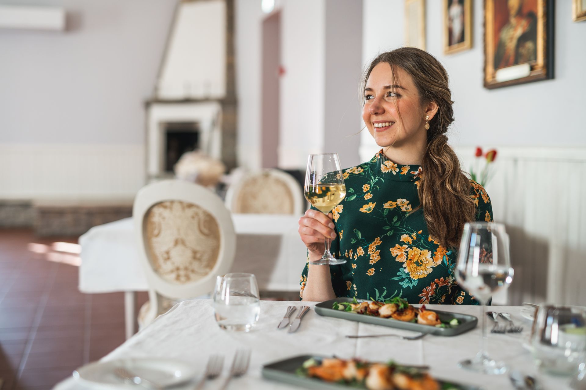 Woman enjoys wine with dinner at Palmse Manor in North Estonia