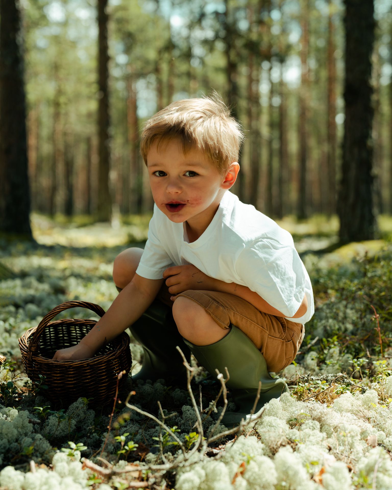 Poiss metsas marju noppimas ja söömas