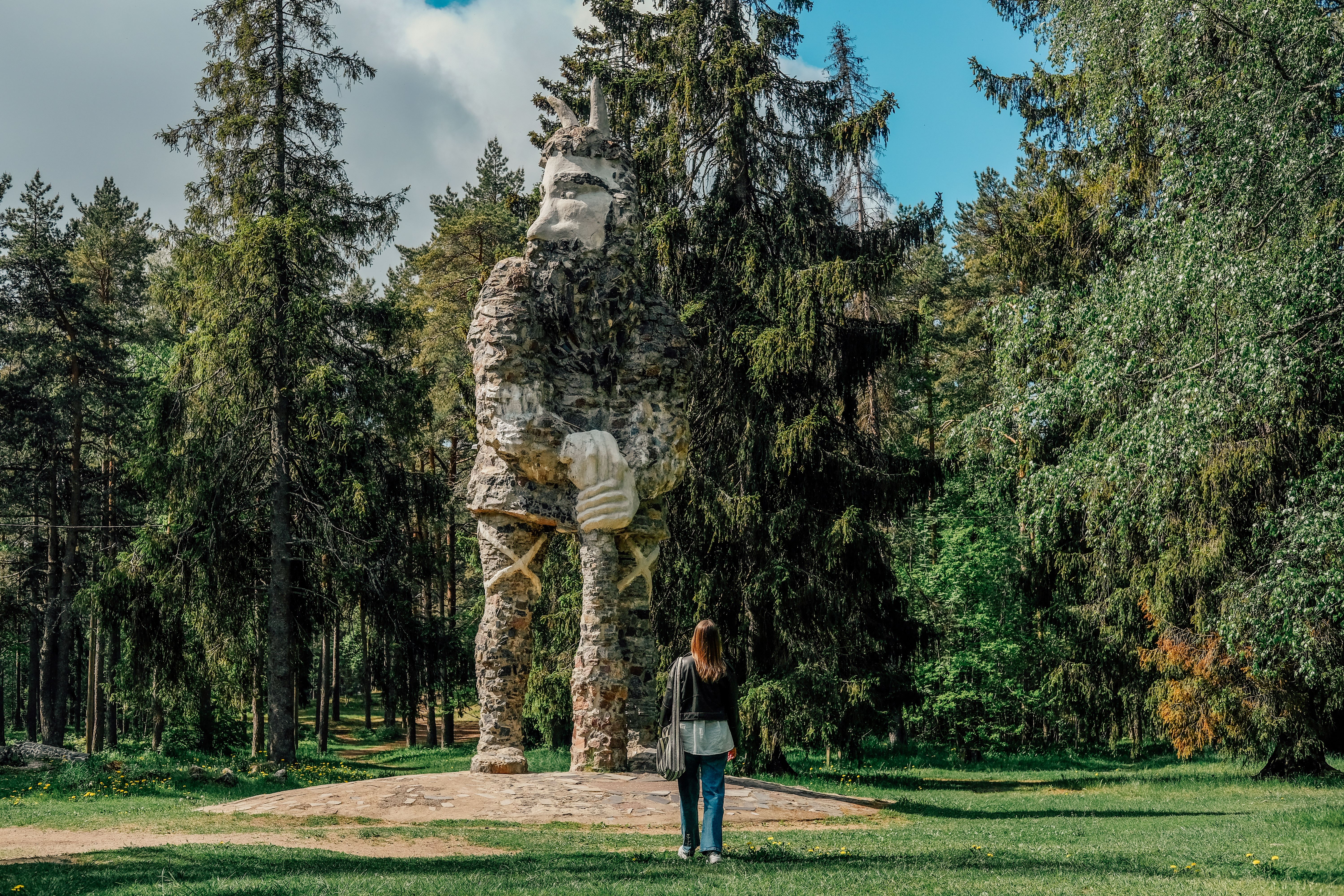 Woman looking at a stone statue of Kalevipoeg in Glehn Park.