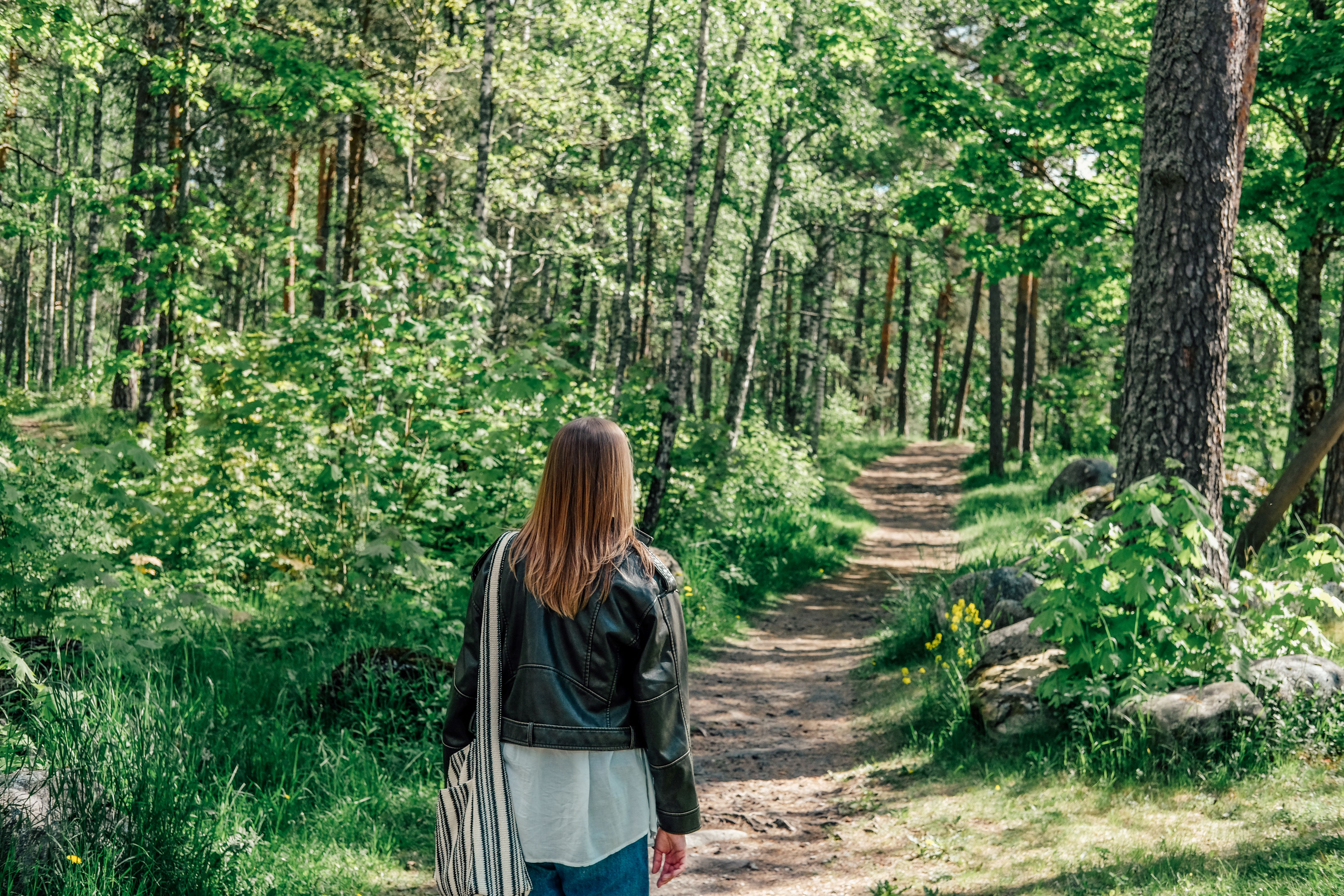 Woman walking in a forest trail in Nõmme-Mustamäe Landscape Protection Area.