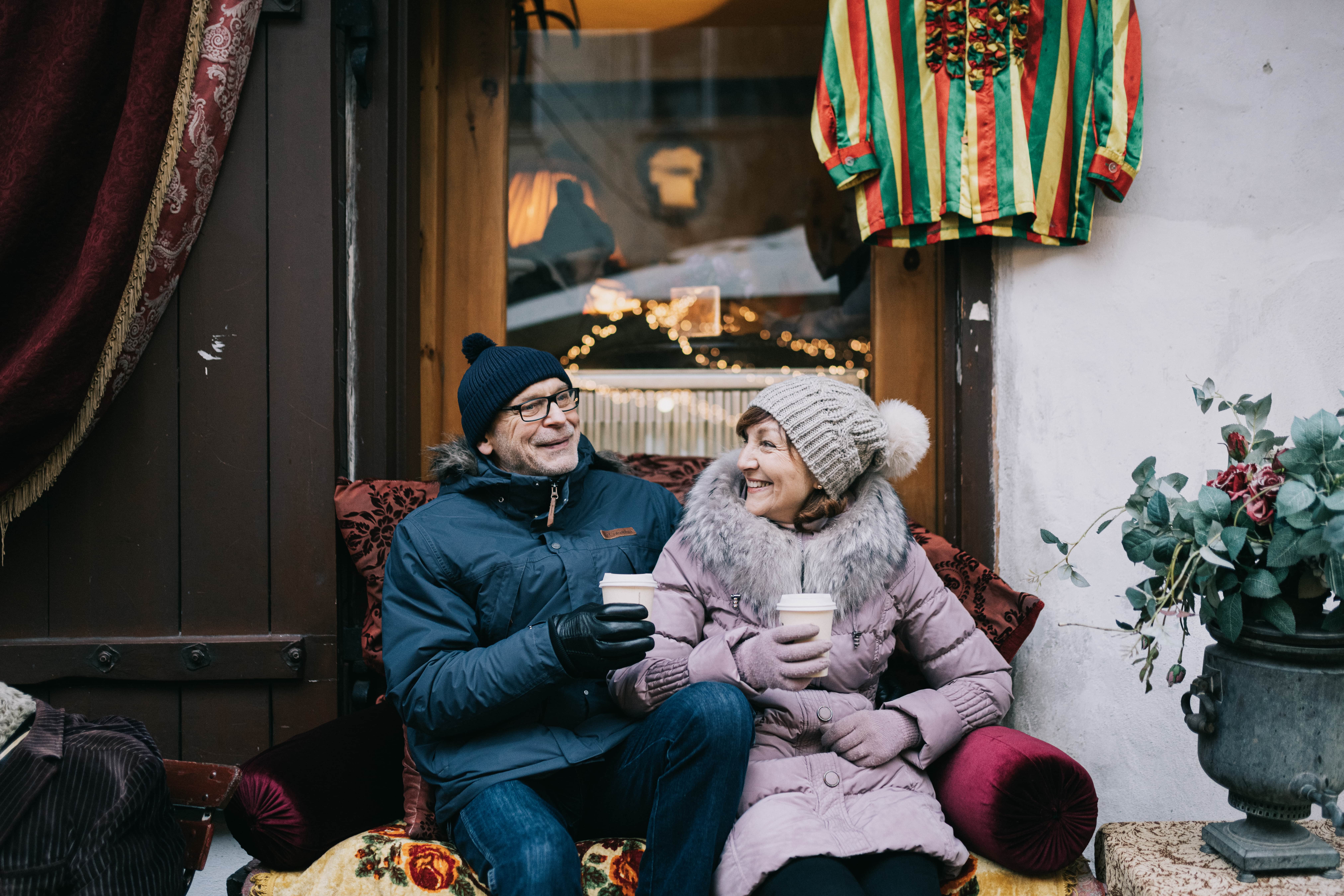 Couple relaxes in front of a coffee shop in Tallinn during the winter