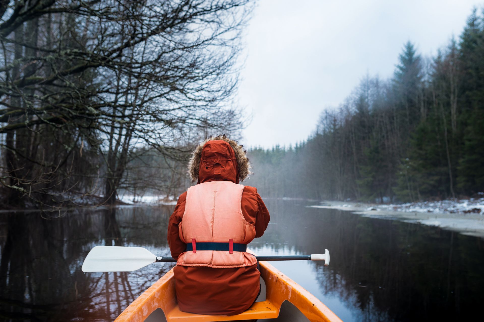 Woman canoeing in Estonian national park during winter