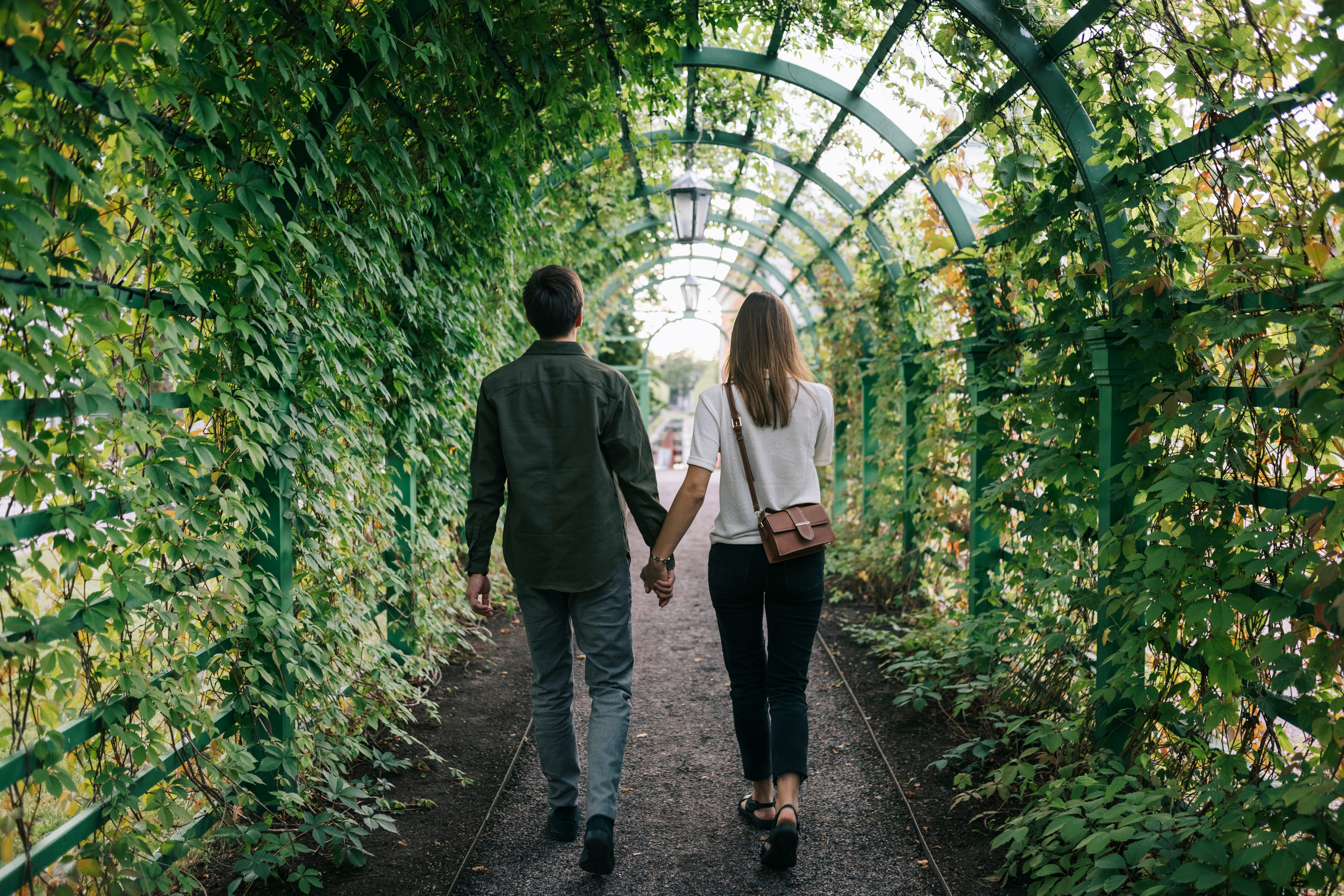 Couple walks through Kadriorg Park holding hands