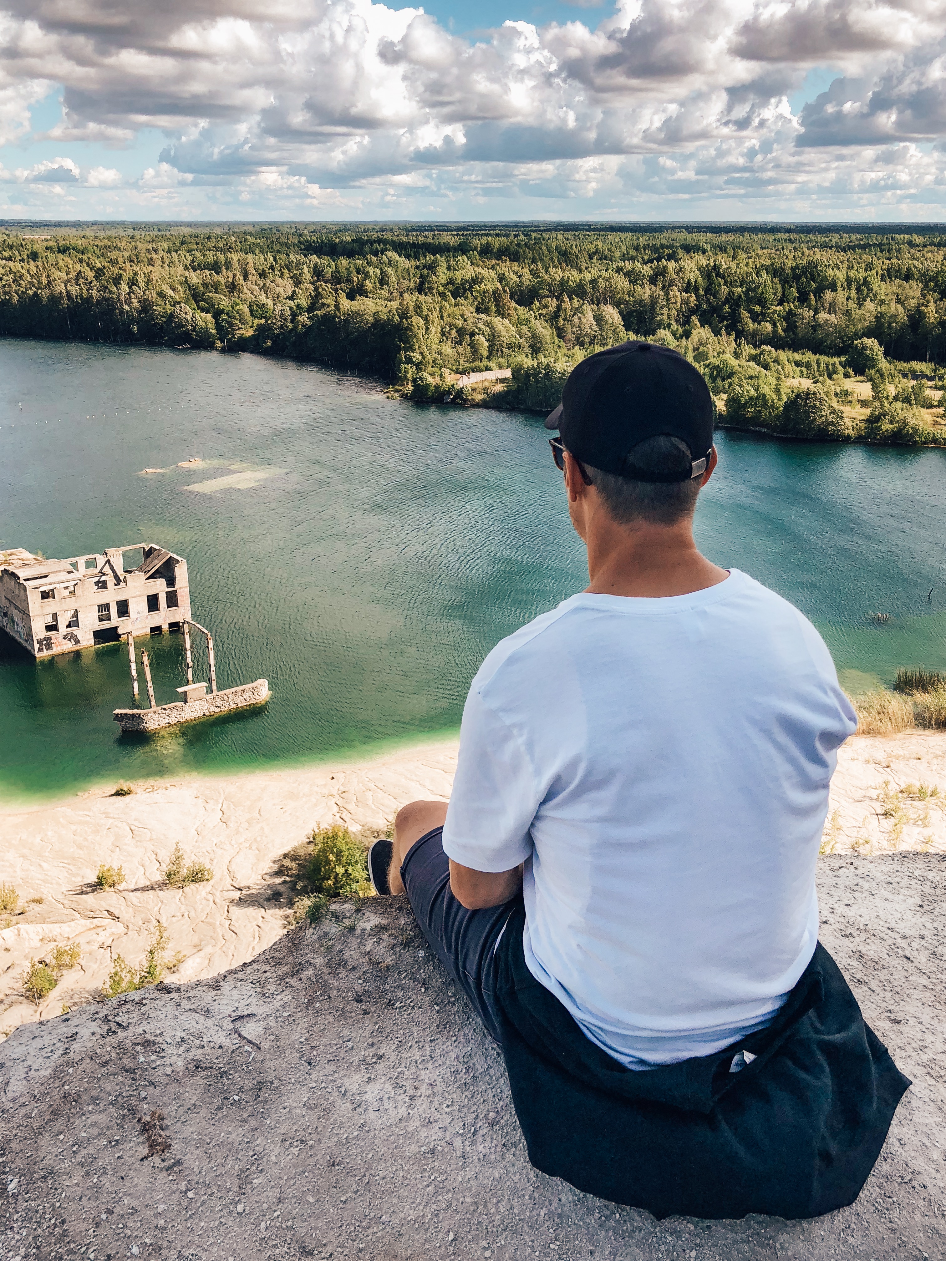 Vīrietis sēžot un skatoties uz Rummu karjeru no augšas vienas dienas braucienā