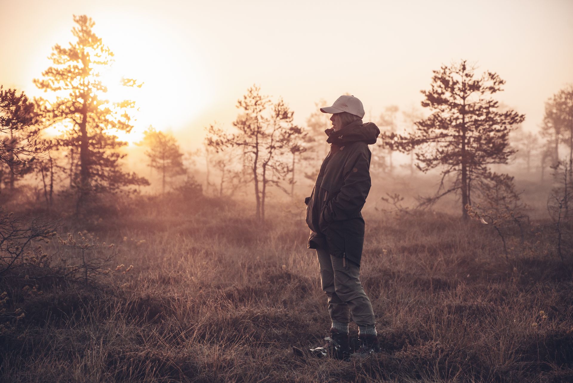 Woman watching the sunset in a bog in Estonia