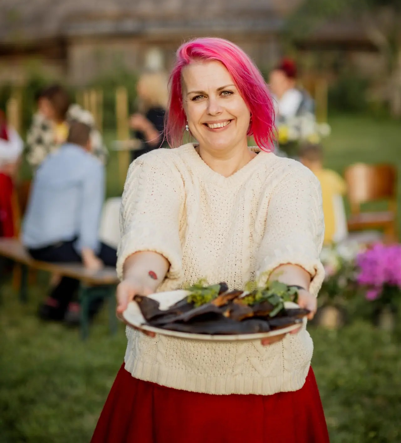 Eine Frau aus Saaremaa mit einem Teller voller lokal geräucherten Fisch 