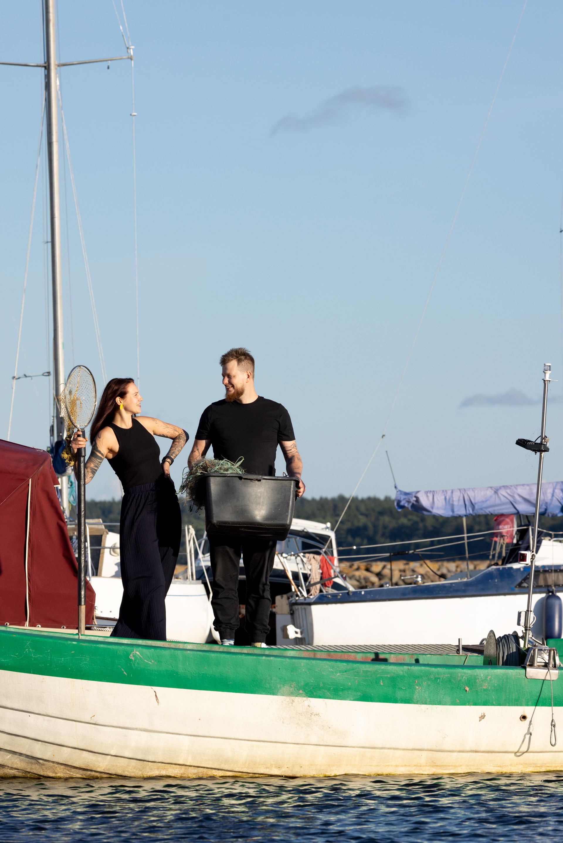 Ein Paar vor einigen Booten im kleinen Hafen von Vergi