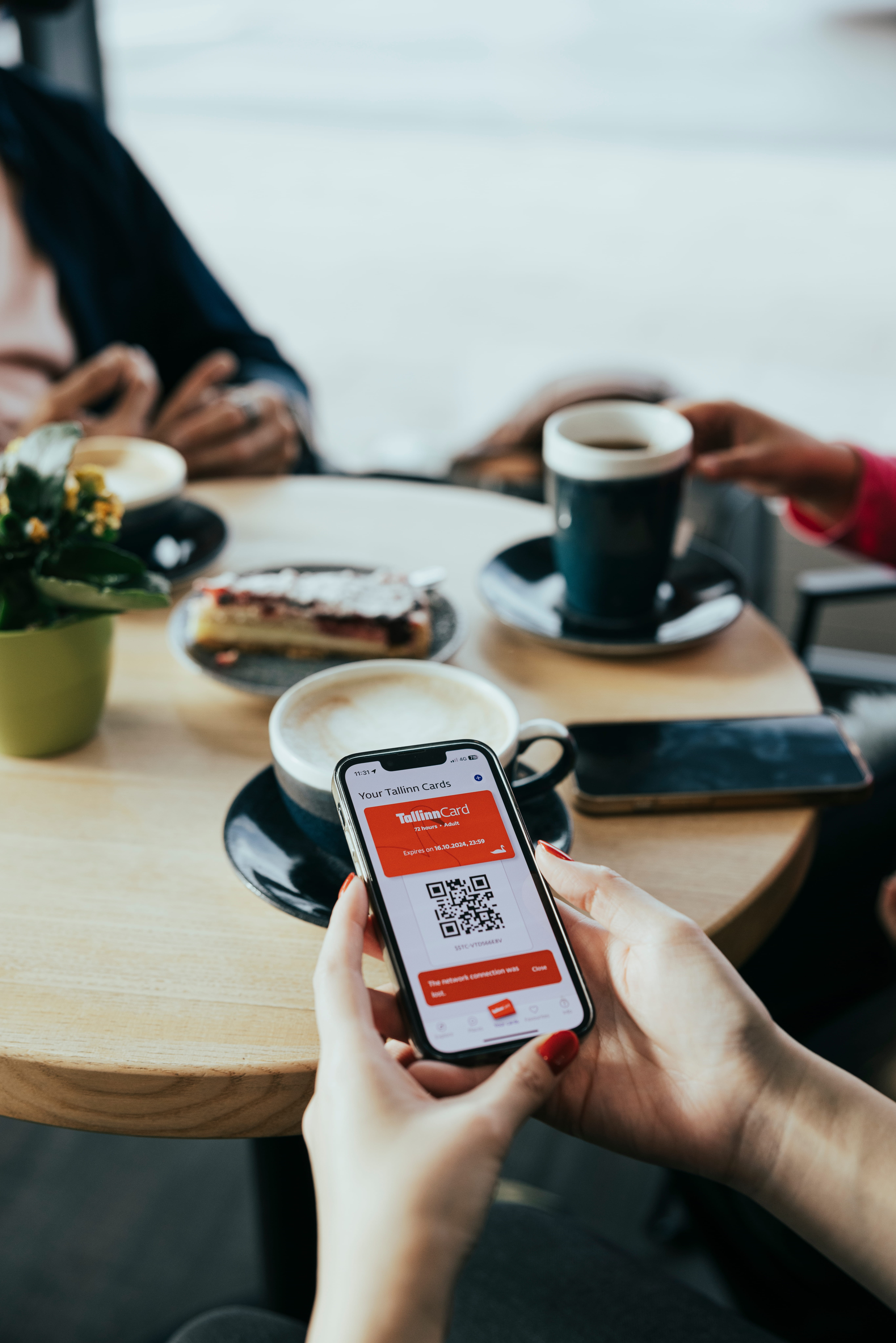 Phone showing Tallinn Card and app with coffee and cake