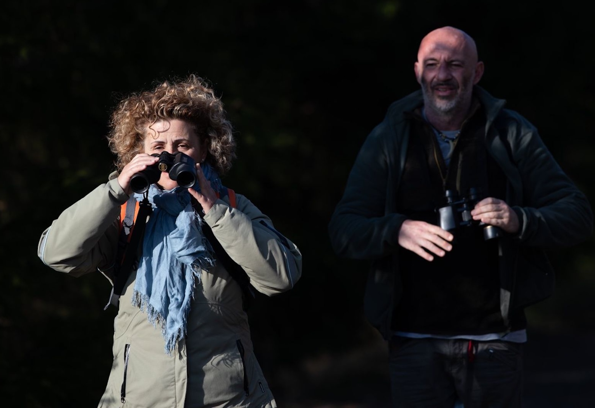 Man and woman with binoculars on wildlife watching tour in Estonia
