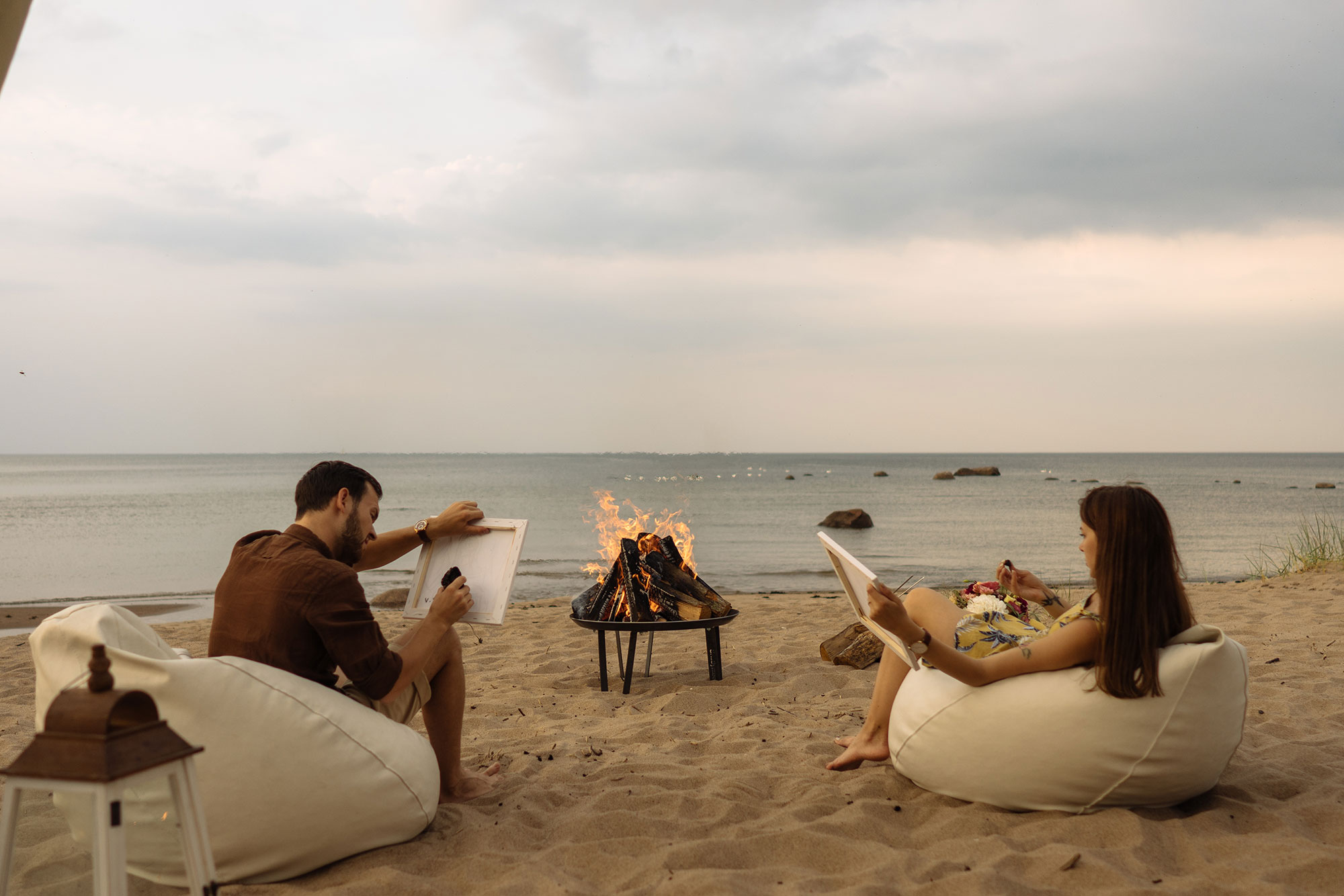 Ein Paar malt am Lagerfeuer am Strand von Pärnu
