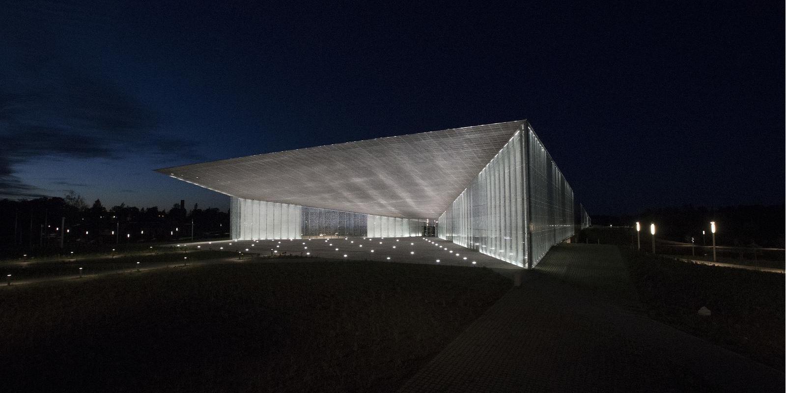 Fotogrāfijā redzama apgaismota Igaunijas Nacionālā muzeja ieeja tumšā vakarā